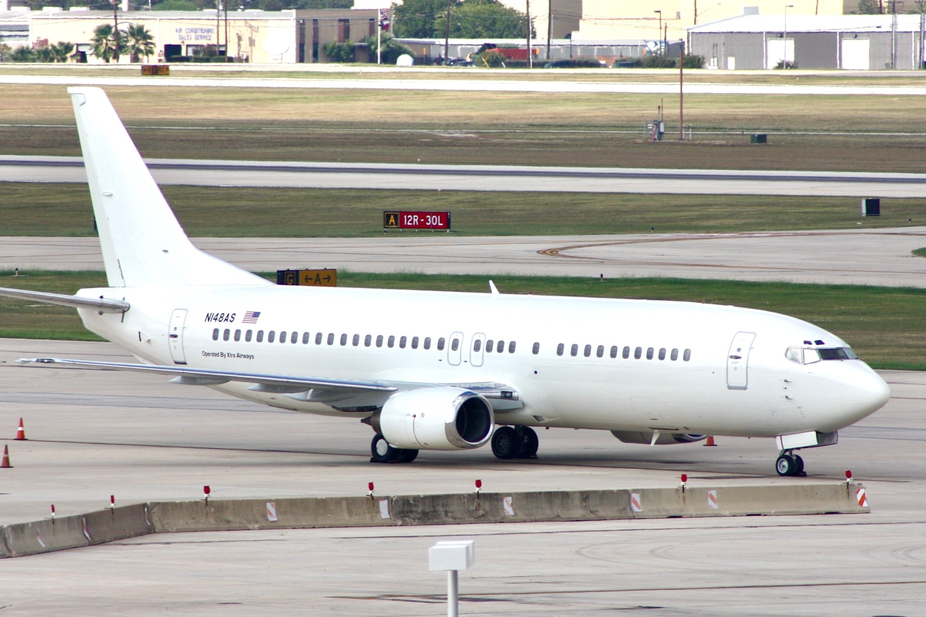 A Plain White Boeing 737-400 Parked on the airport apron in San Antonio.