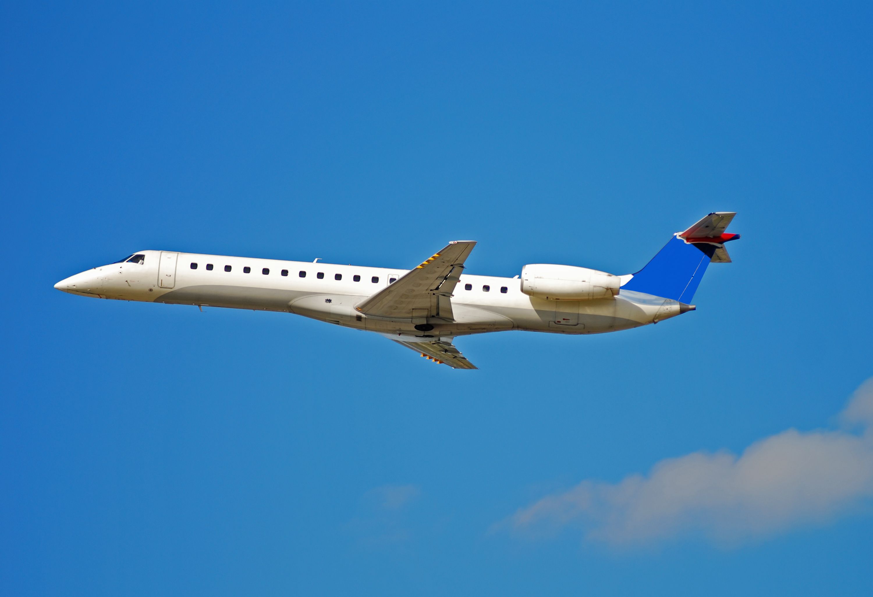 An Embraer regional jet flying in the sky.
