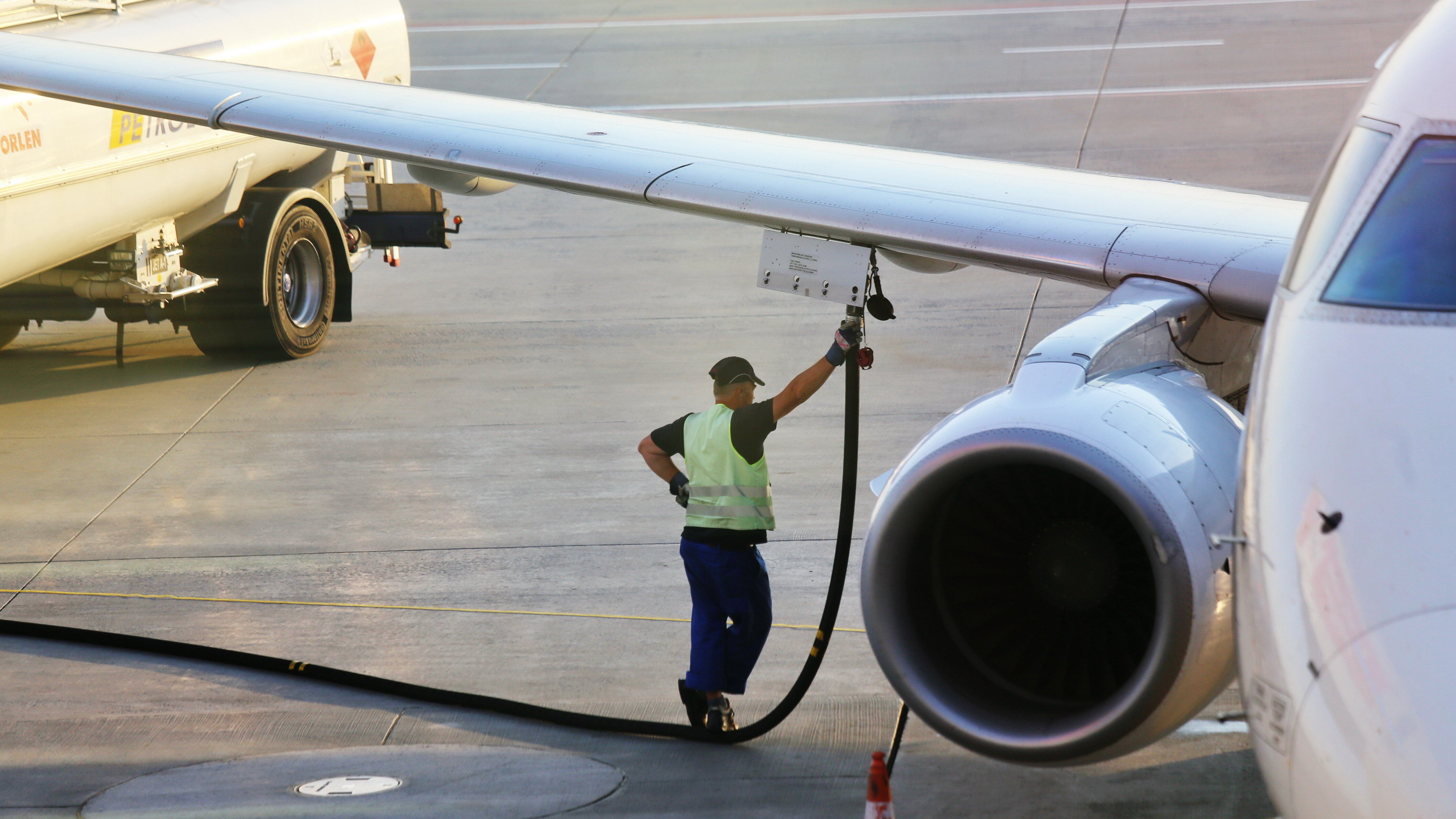 A ground crew worker refueling an aircraft.