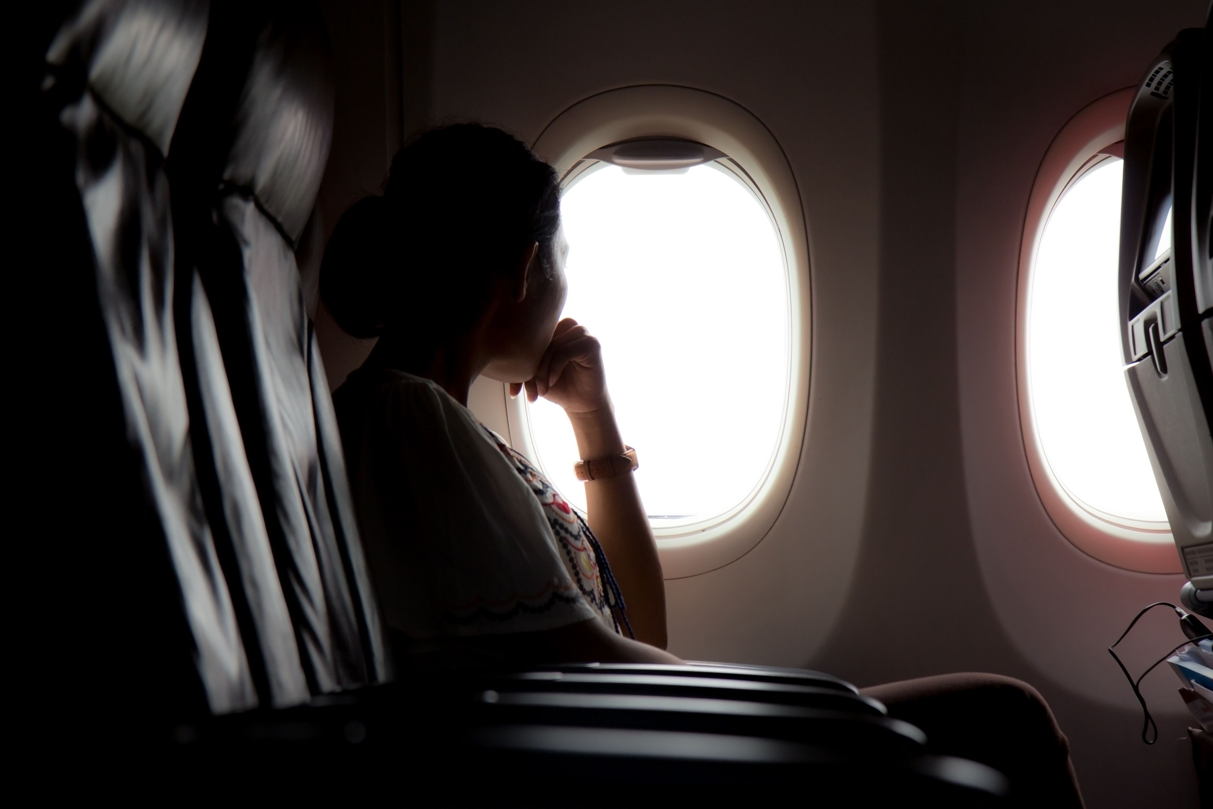 A passenger looking out of the window of an airliner.