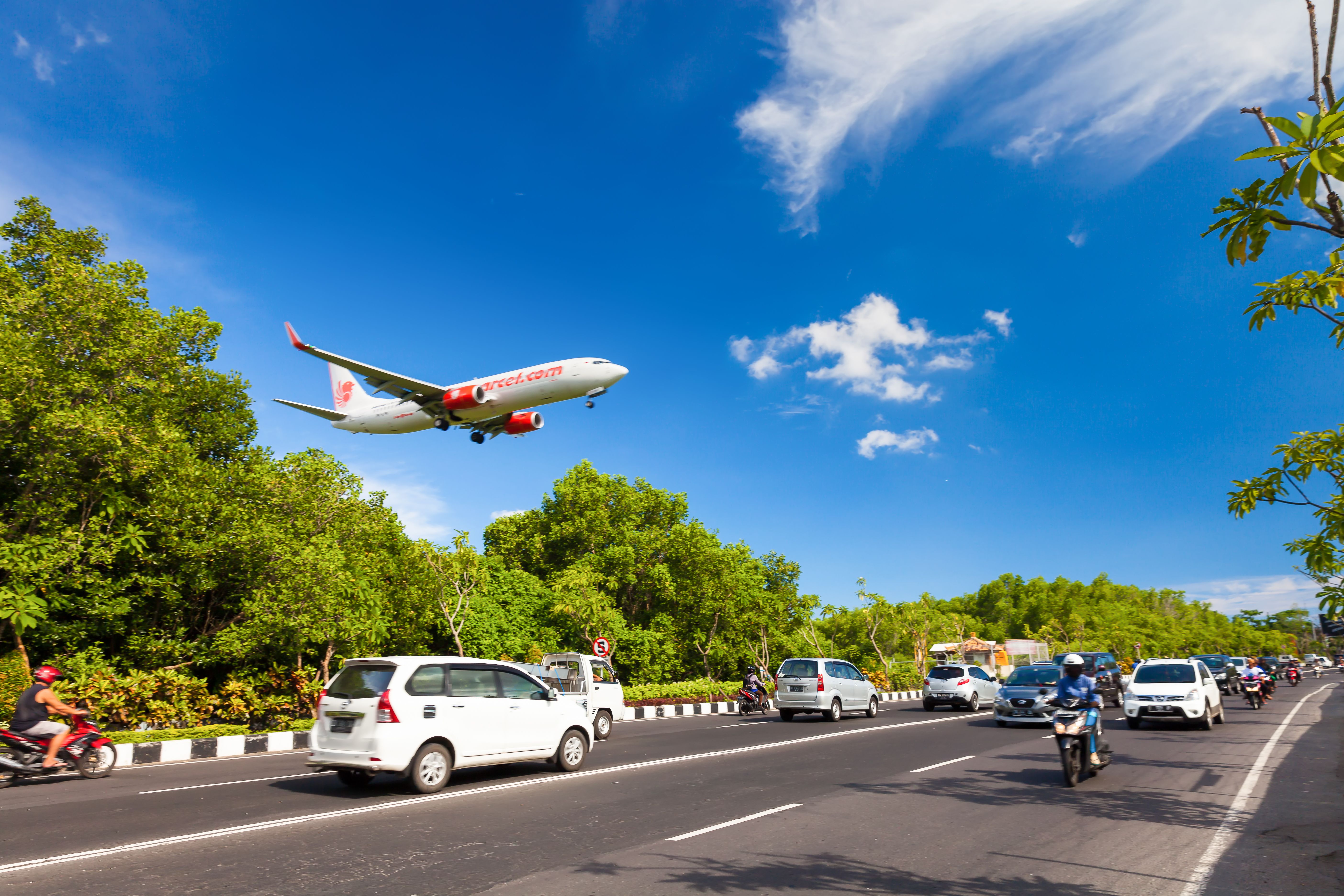 shutterstock_496294081 BALI, INDONESIA - FEBRUARY 19, 2016 Plane in motion, Airlines plane company Lion air flying between the trees makes a dangerous landing close to the ground in International Airport DFS / Indonesia