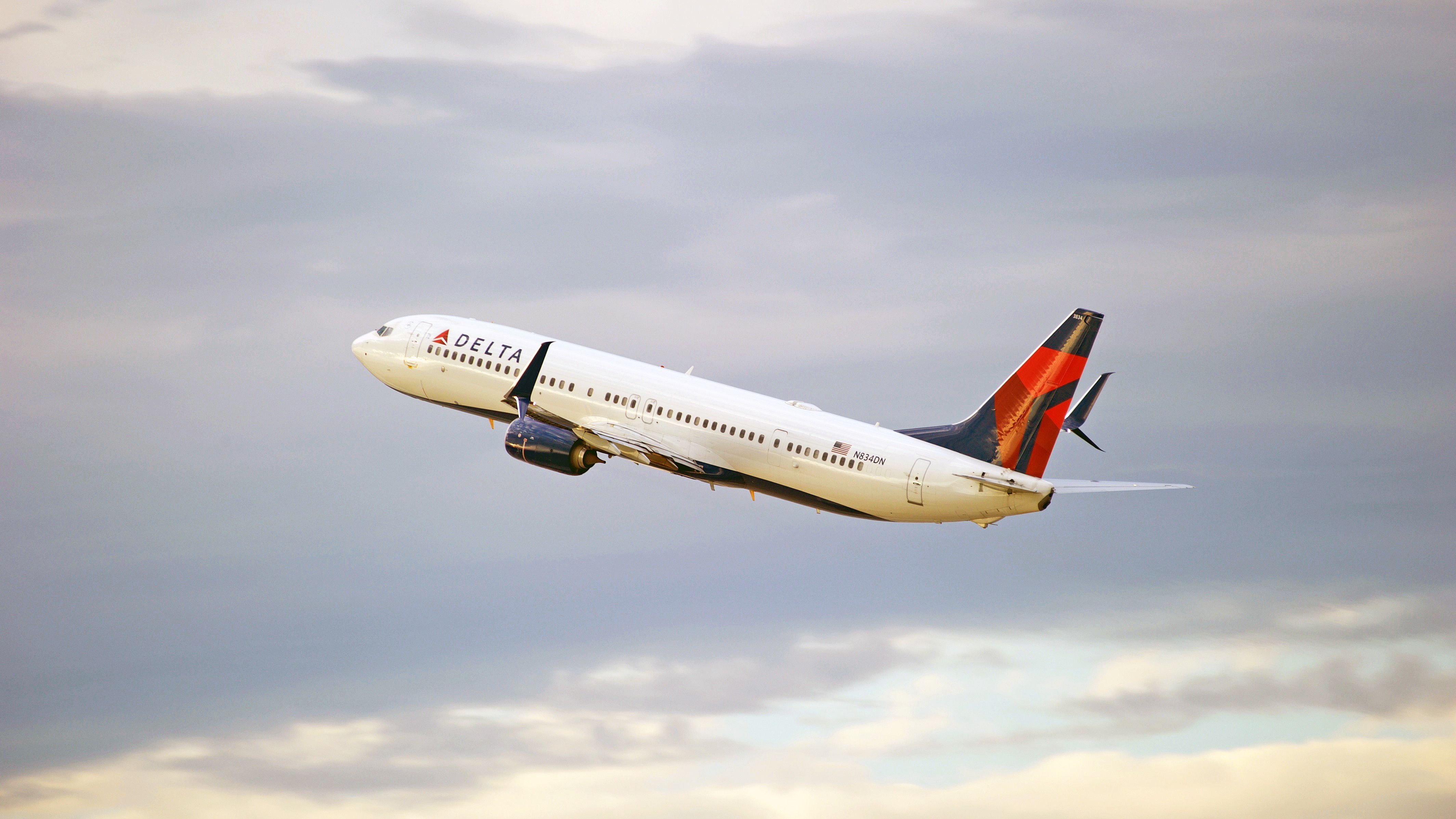 A Delta Air Lines Boeing 737-900ER flying in the sky.