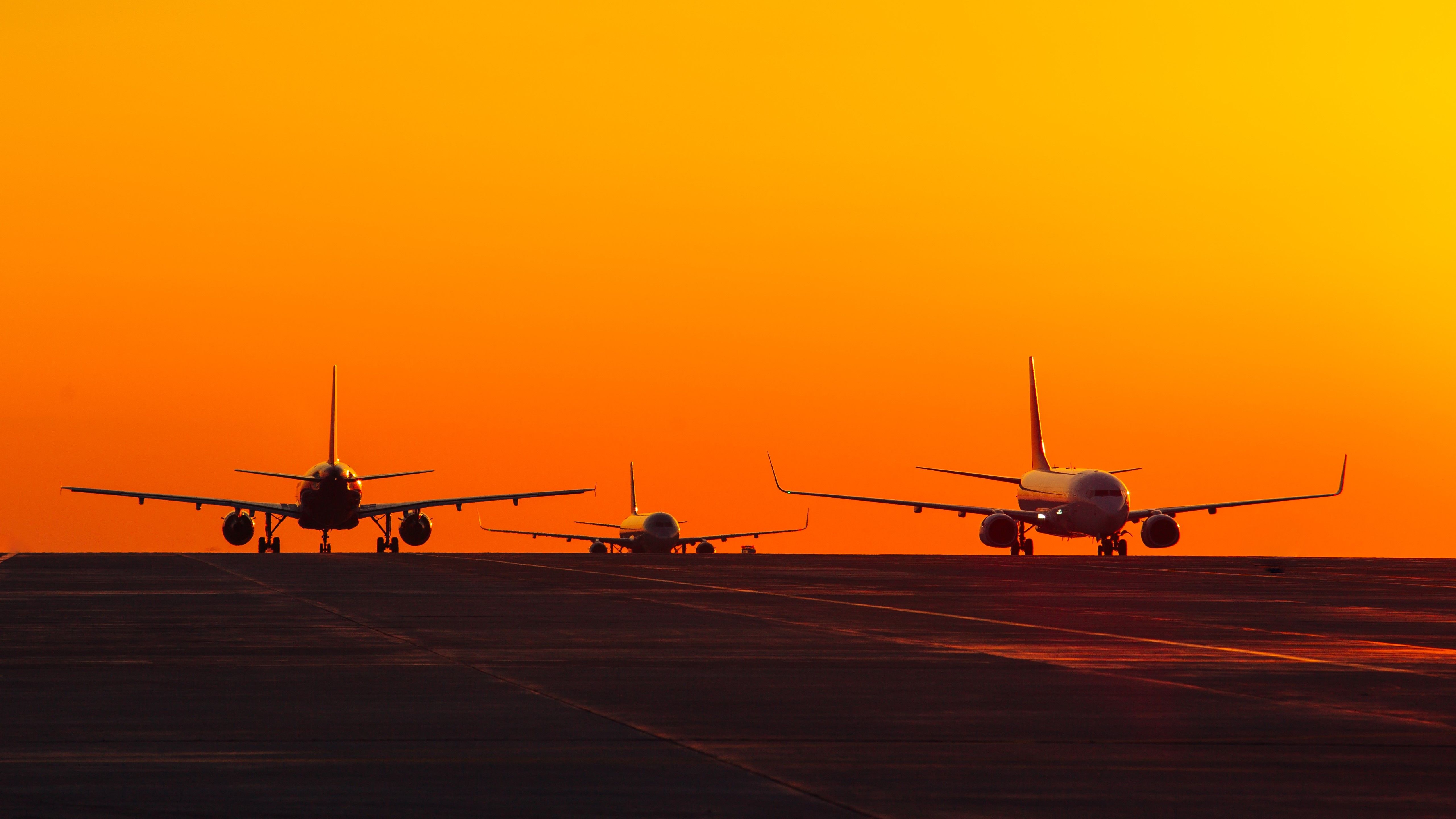 3 aircraft on ground with sunset sky