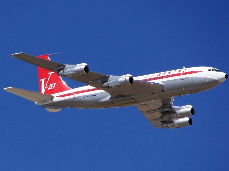 A Qantas Boeing 707 flying in the sky.
