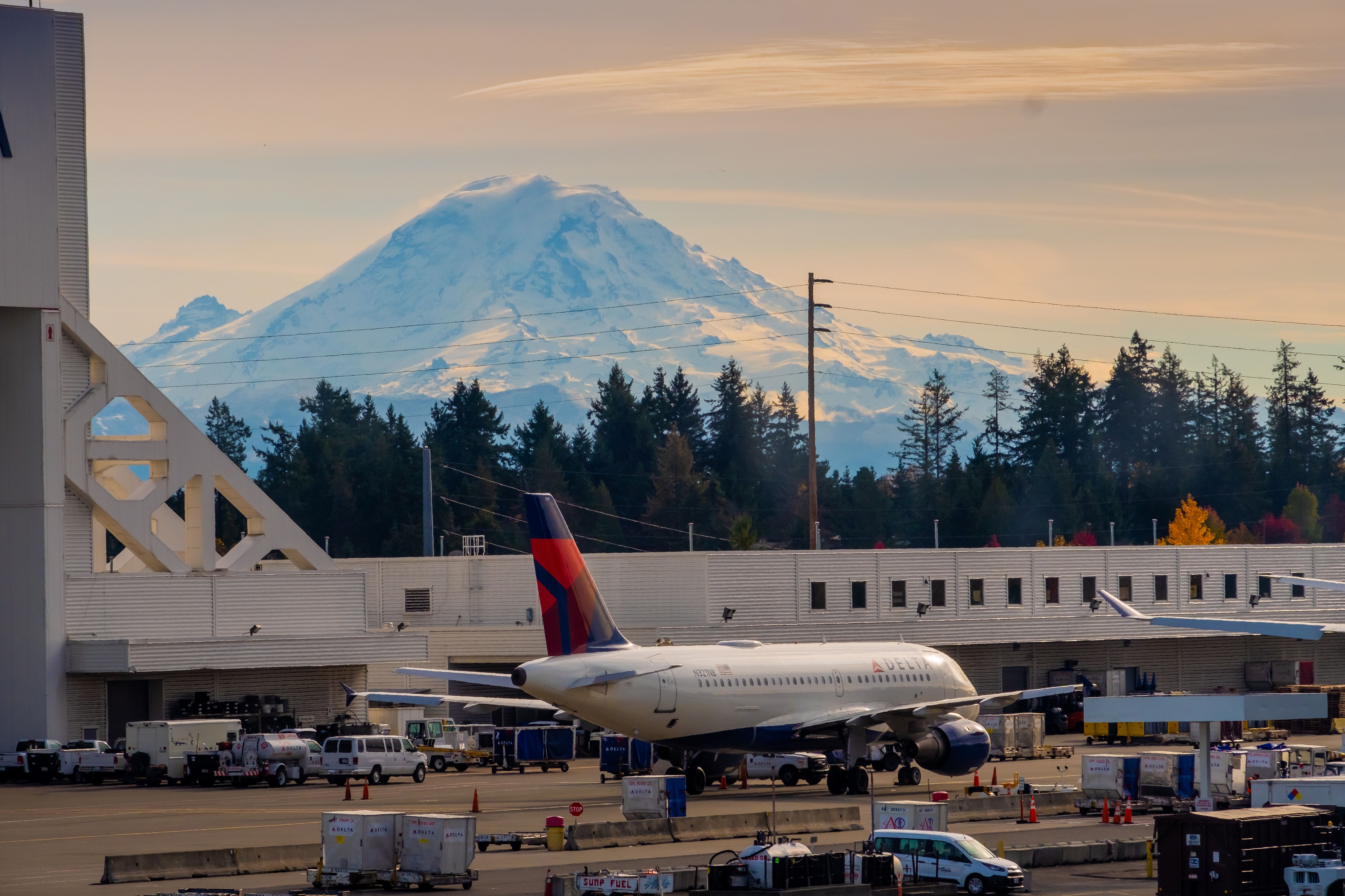 View of Seattle Tacoma International Airport SEA with a Delta Air Lines aircraft and a mountain in the background shutterstock_1964960533