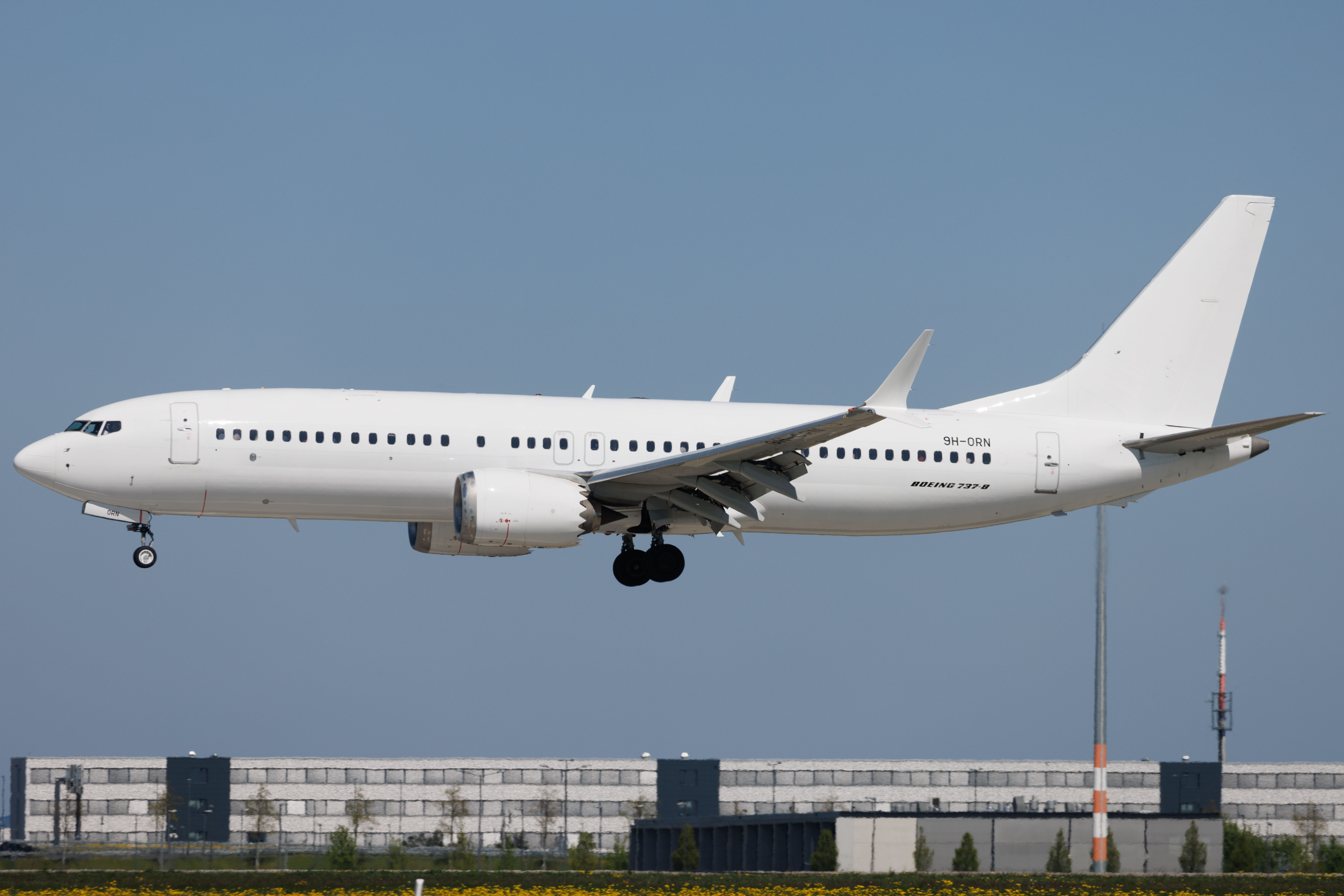 All-white Boeing 737 MAX 8 landing at Berlin Brandenburg Airport BER shutterstock_2328521647