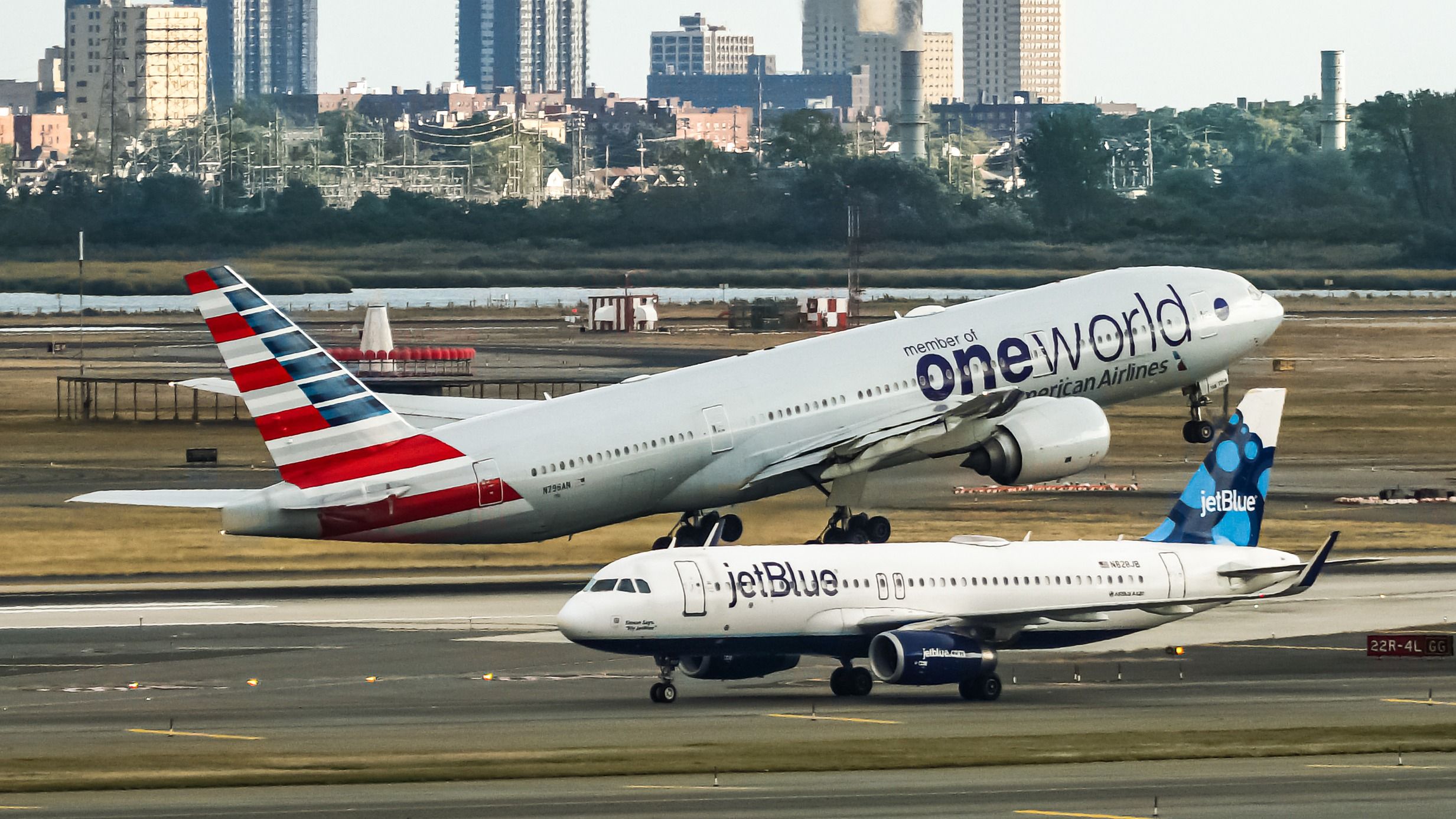 American Airlines Boeing 777 departing JFK with a JetBlue Airbus A320 in the foreground shutterstock_1527434531