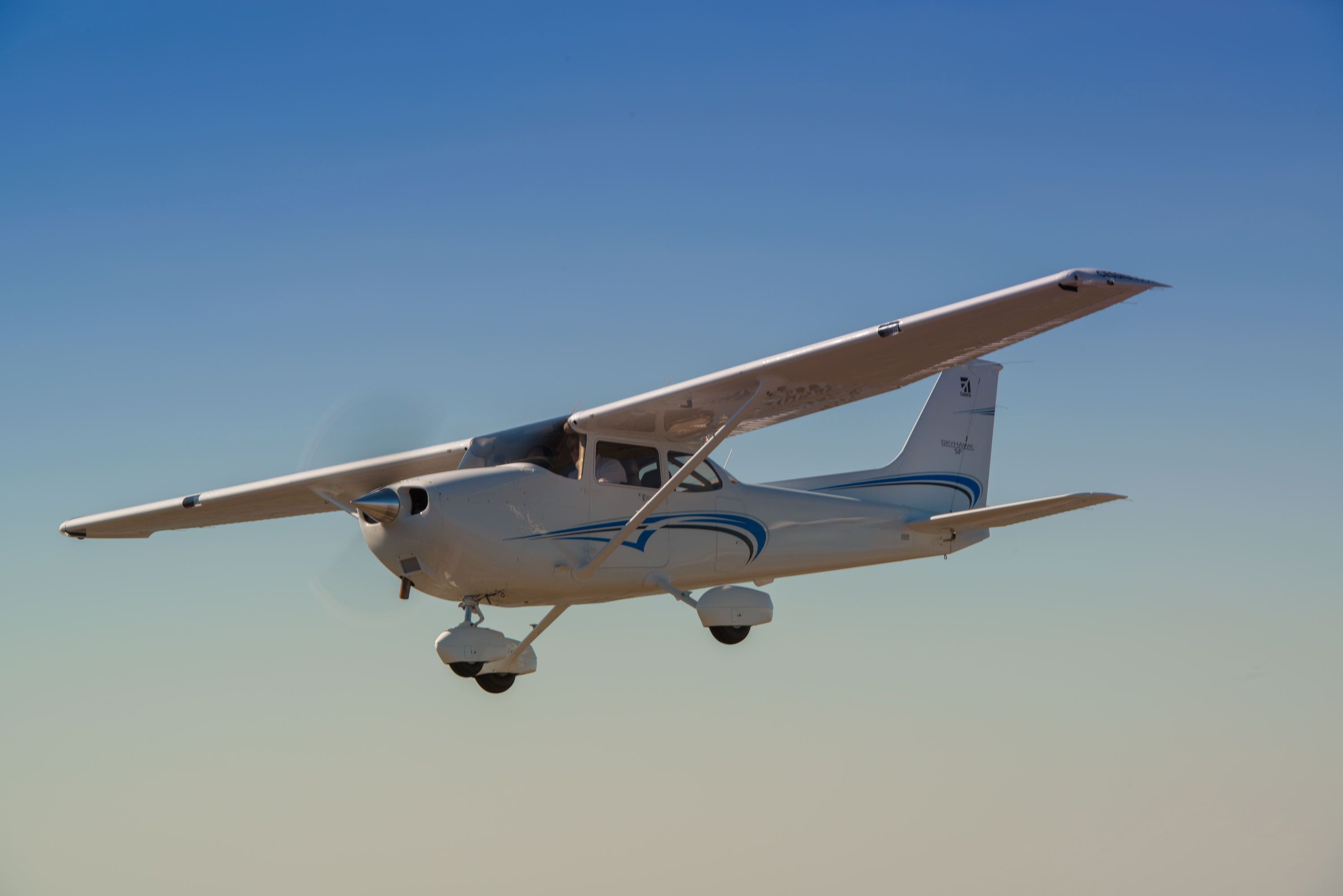 A Cessna 172S Skyhawk flying in the sky.