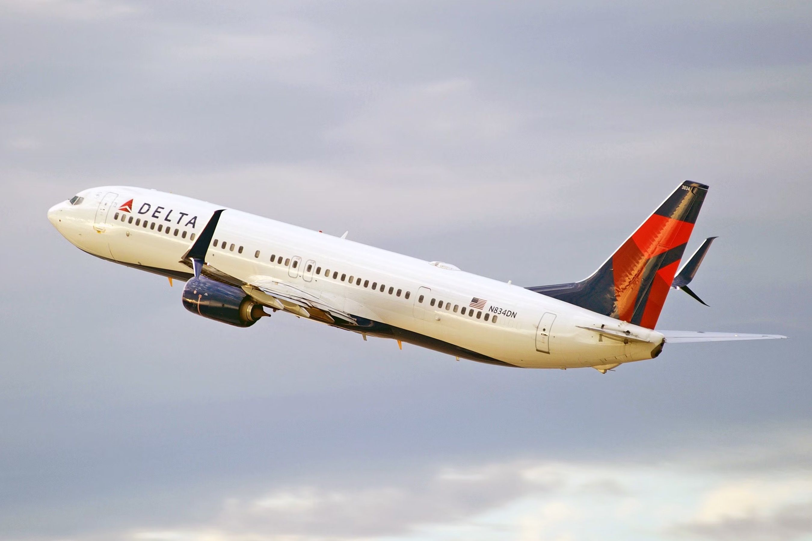 A Delta Air Lines Boeing 737-900ER flying in the sky.
