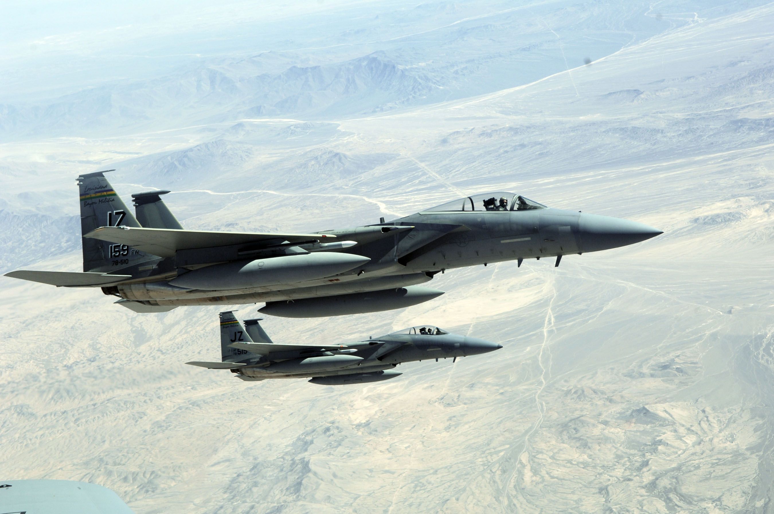 Two F-15s flying over the land