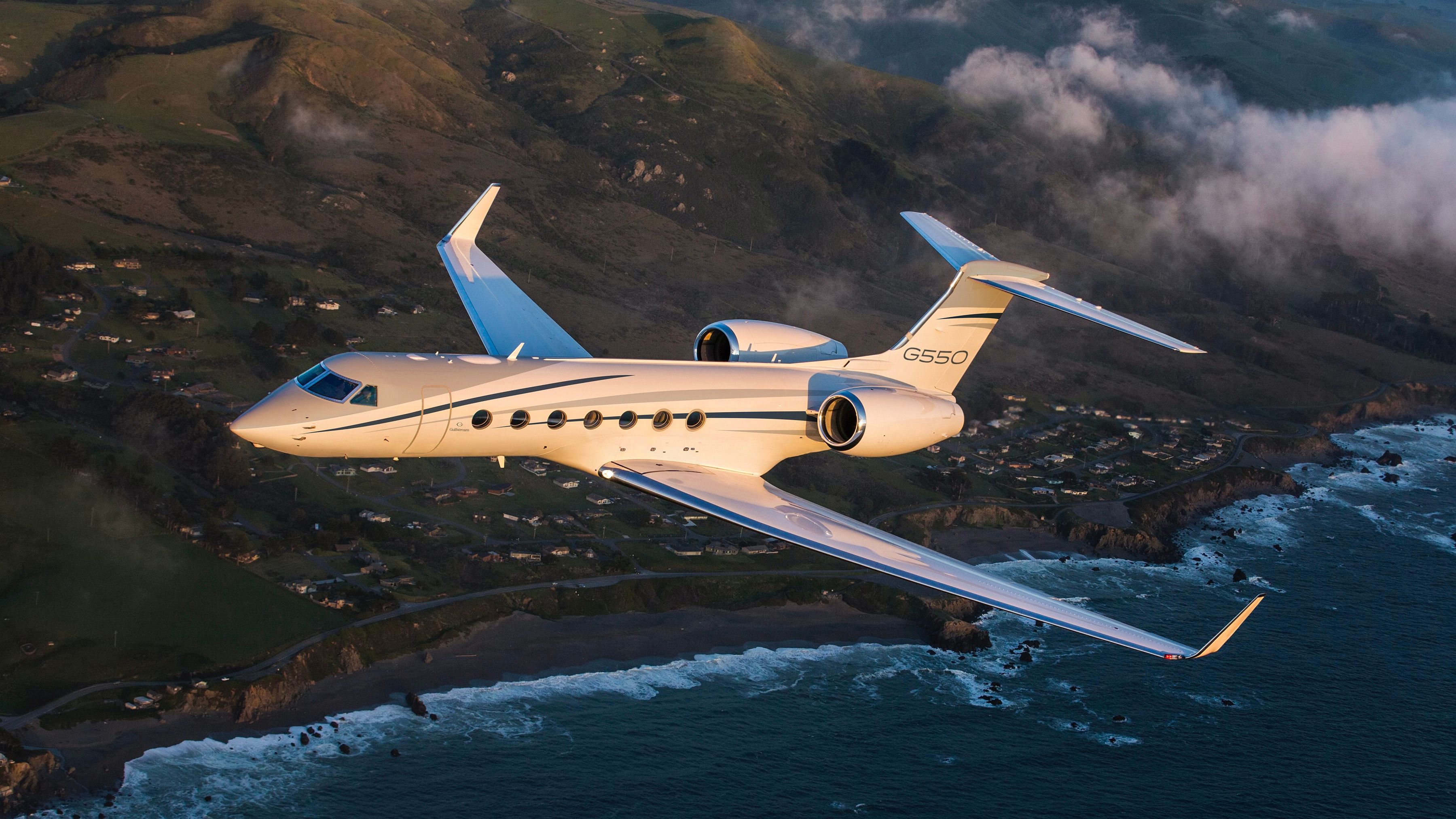 G550 Gulfstream flying over ocean and land