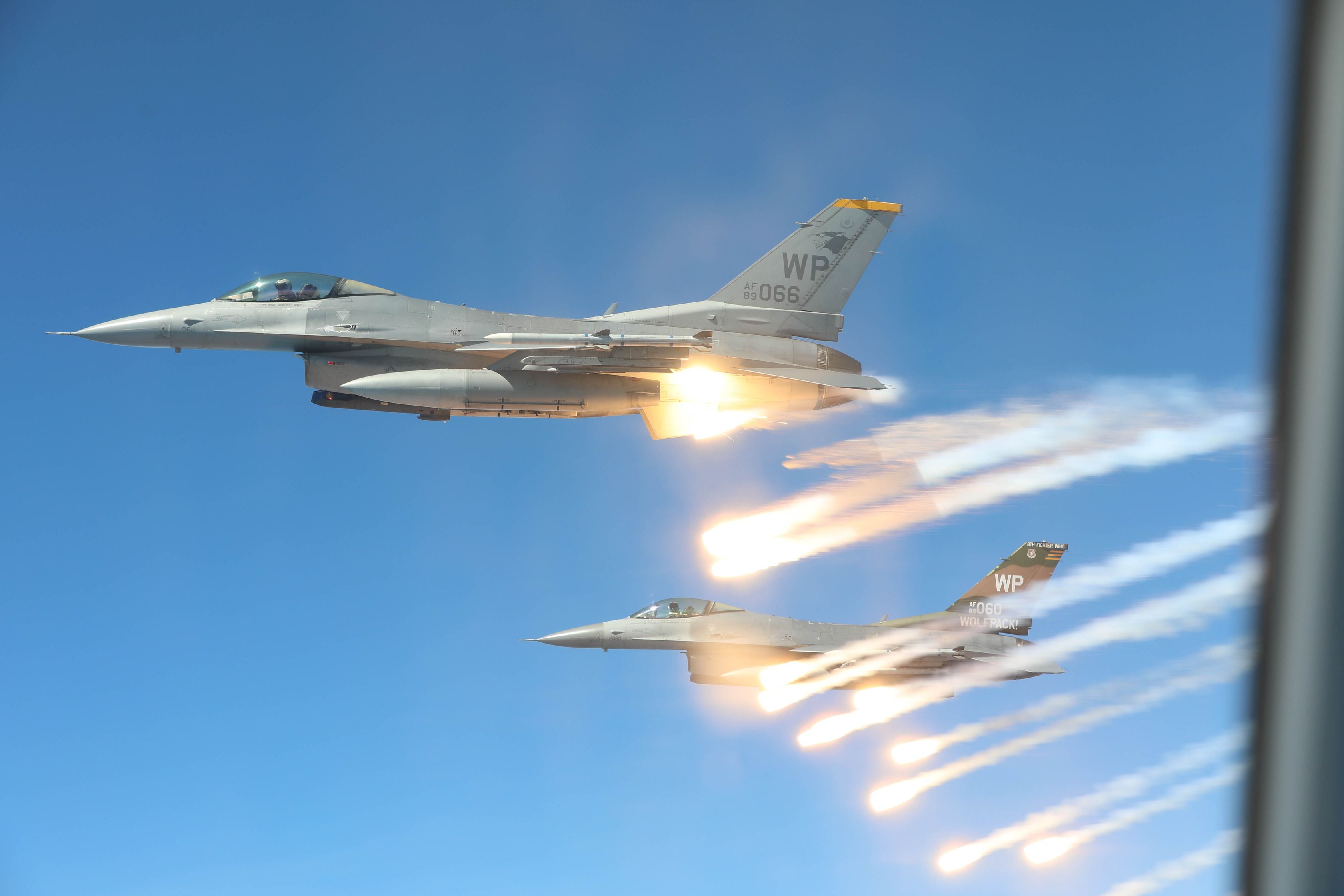 Two Lockheed Martin F-16 Fighting Falcons deploying flares.
