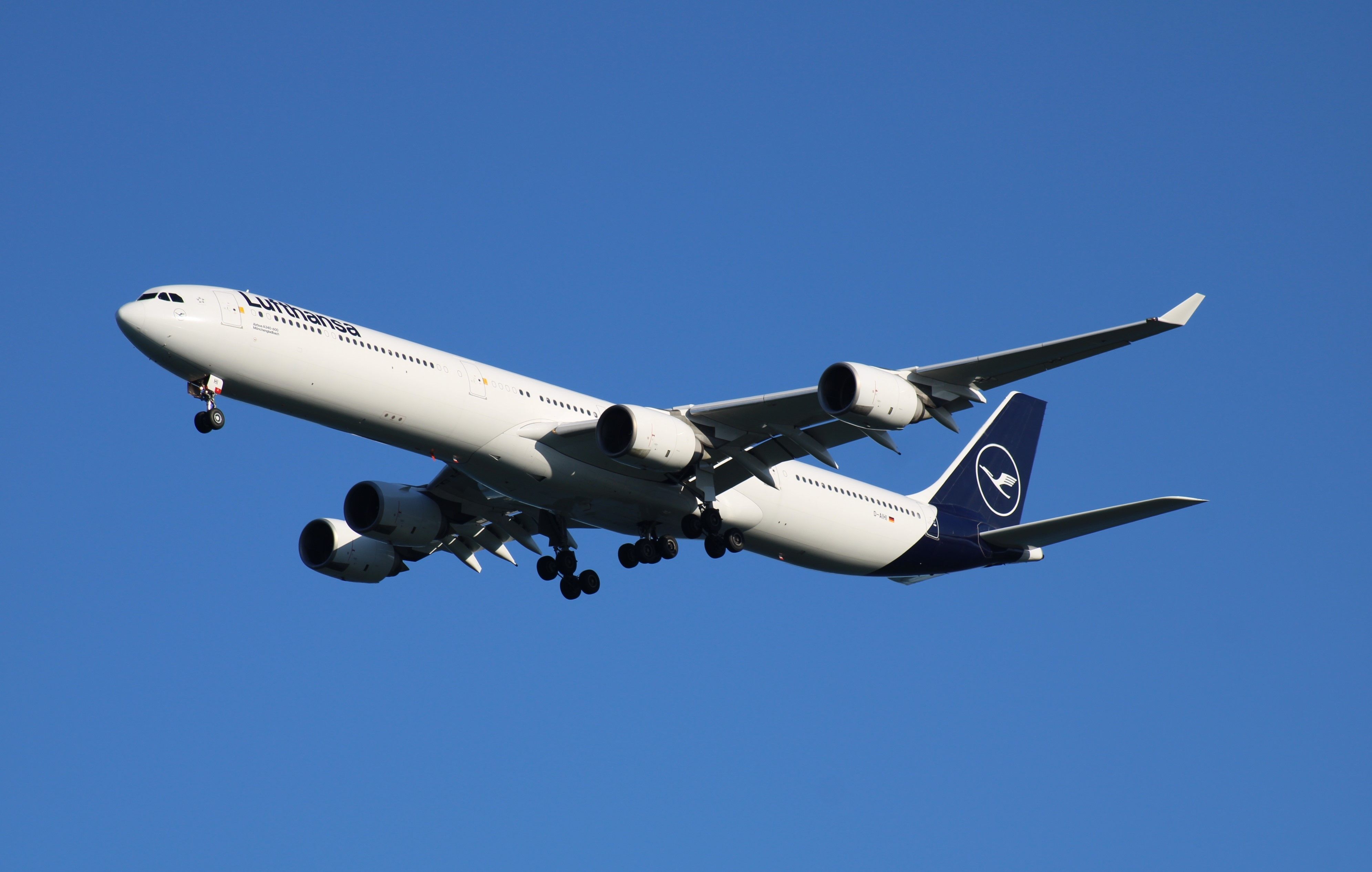 A Lufthansa Airbus A340-600 flying in the sky.
