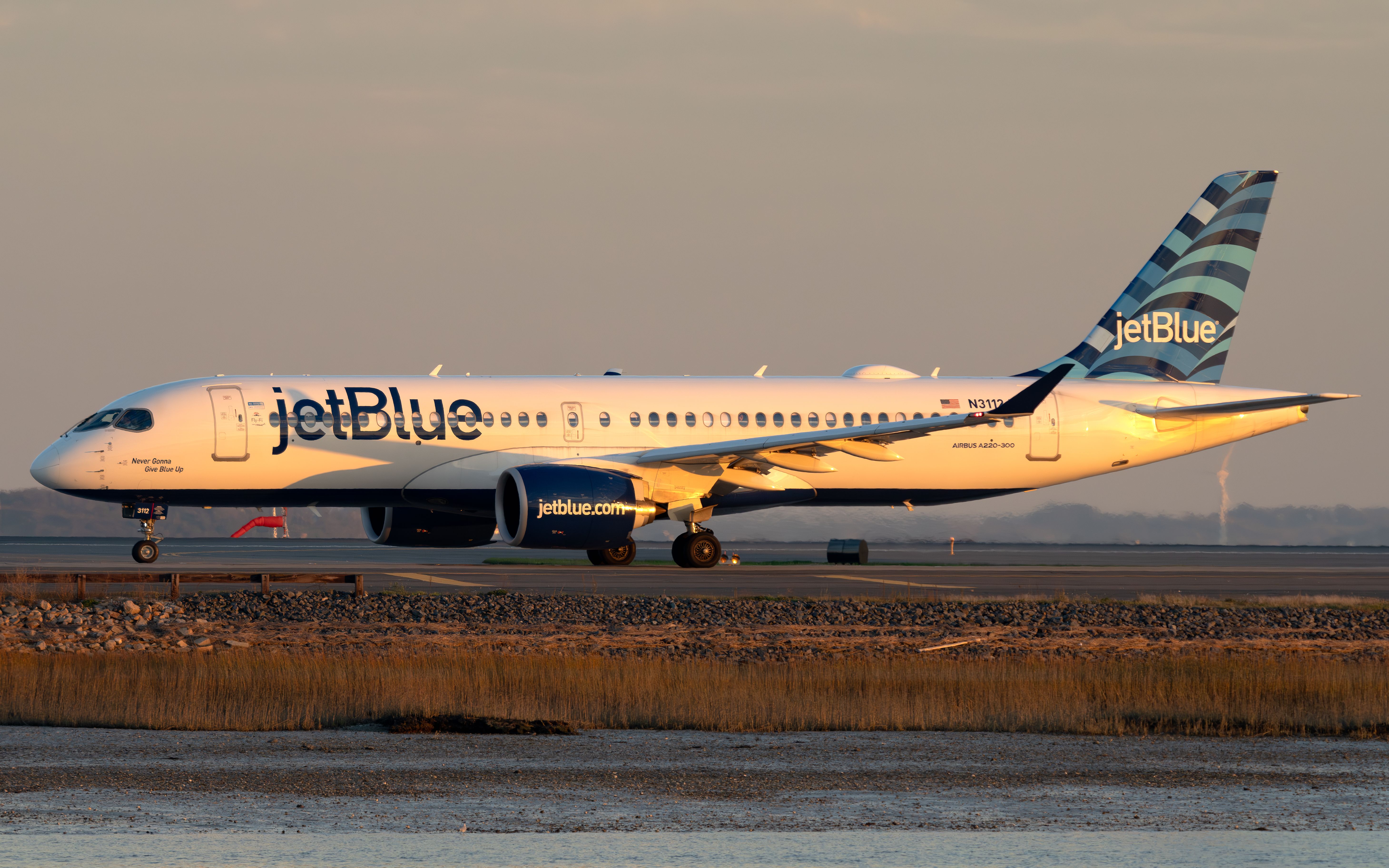 A JetBlue Airways Airbus A220-300 on an airport apron.