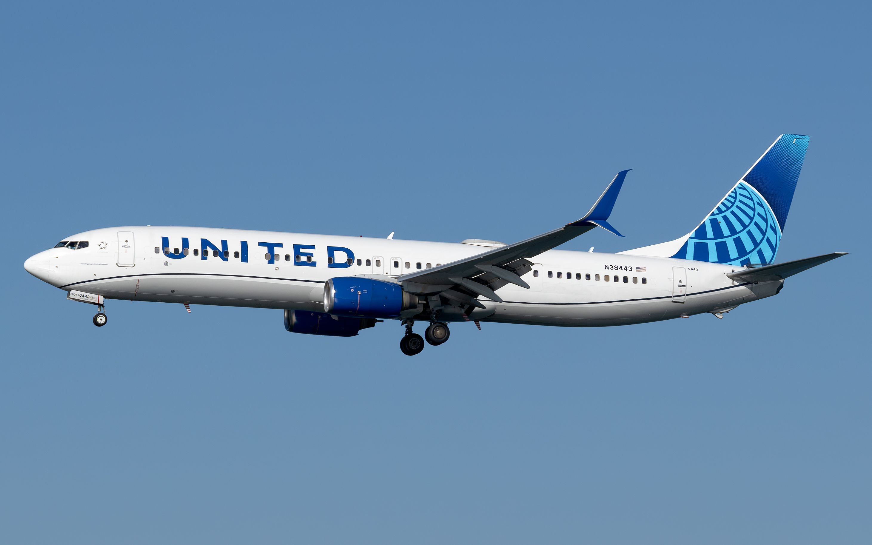A United Airlines Boeing 737-900 flying in the sky.