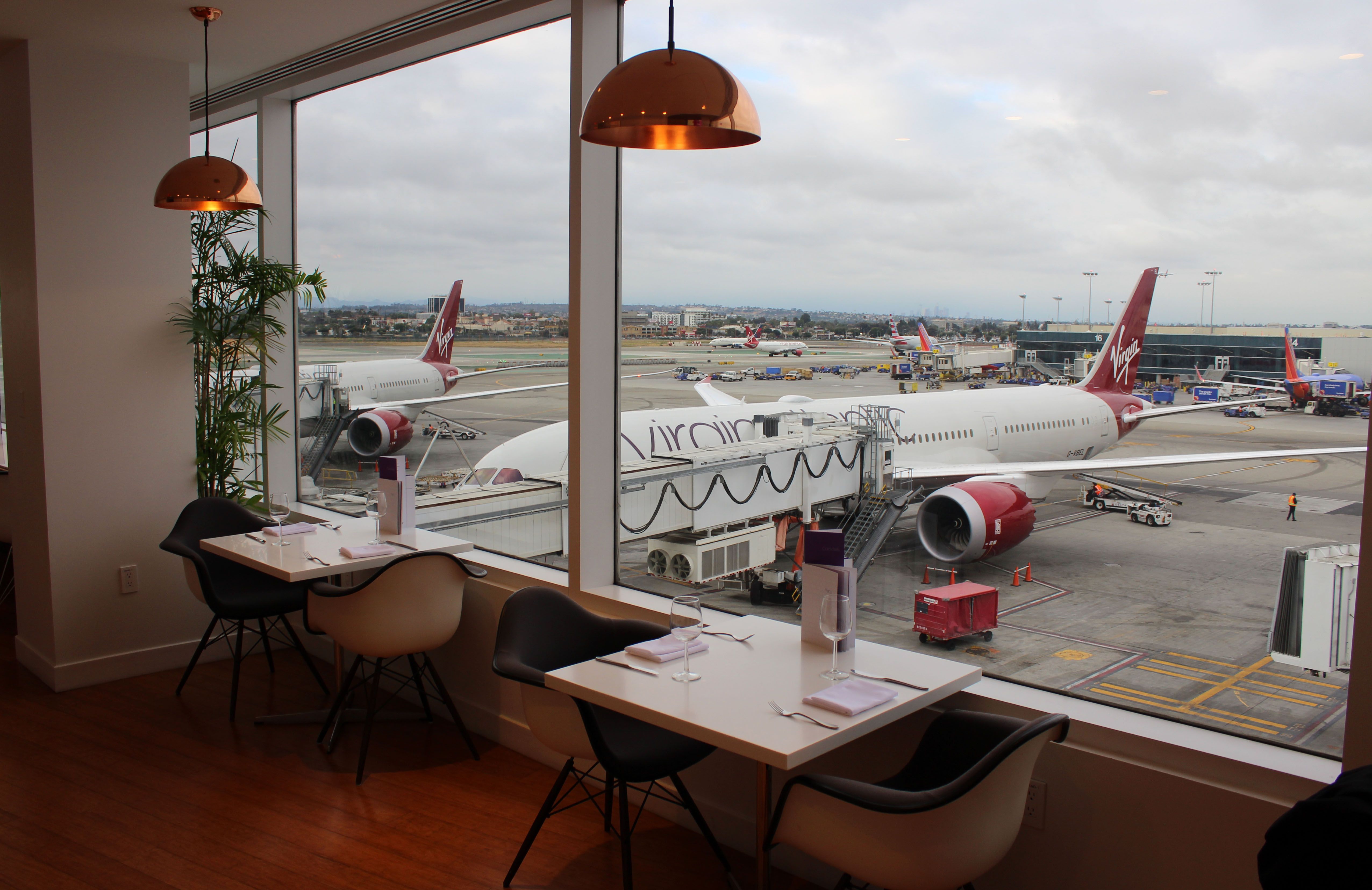 Two Virgin Atlantic Aircraft seen from inside a lounge parked on an airport apron.