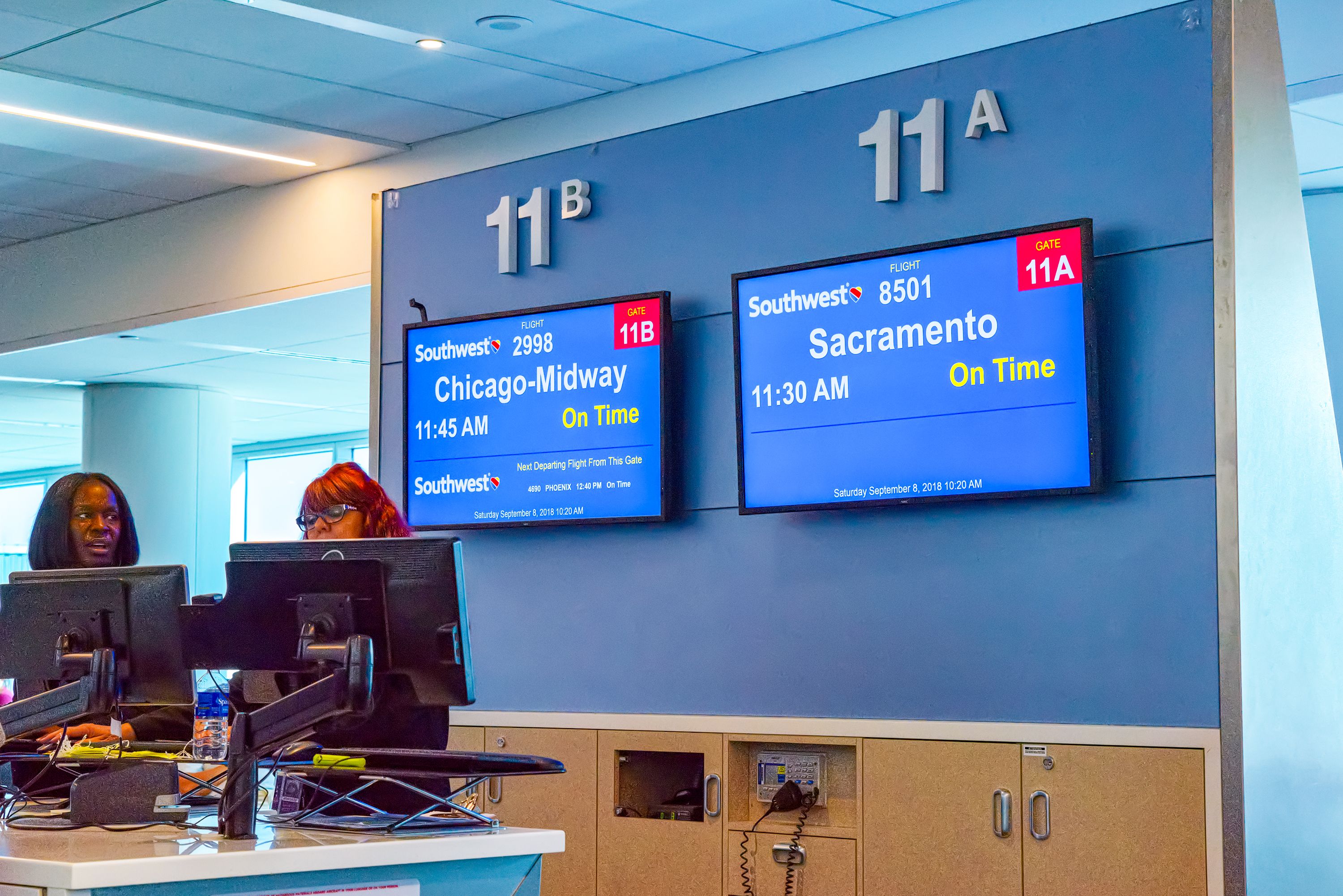 Two airport gate screens showing information for Southwest Airlines flights to Sacramento and Chicago.