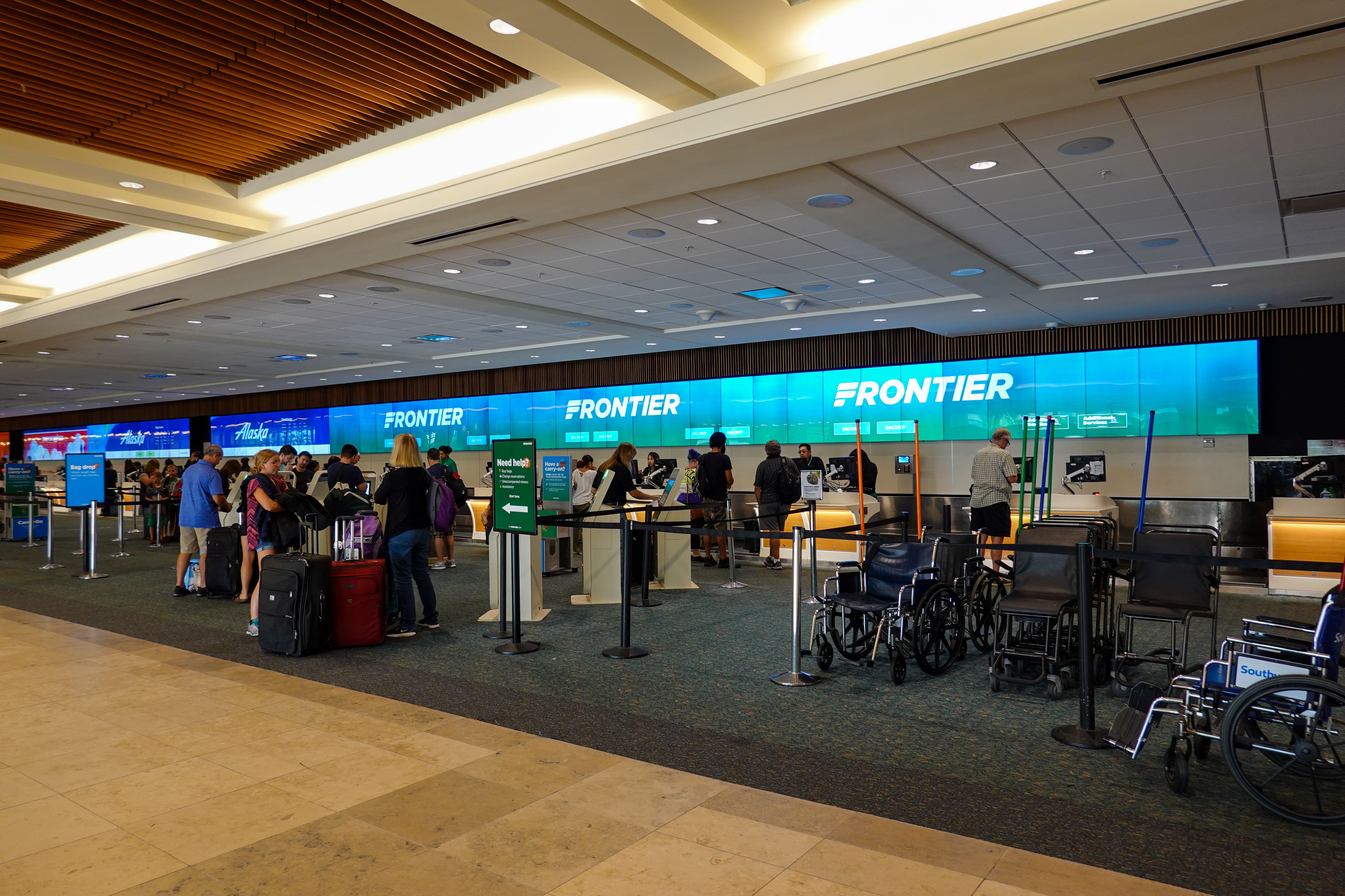 Many passengers checking in for Frontier Airlines flights at the check in counter.