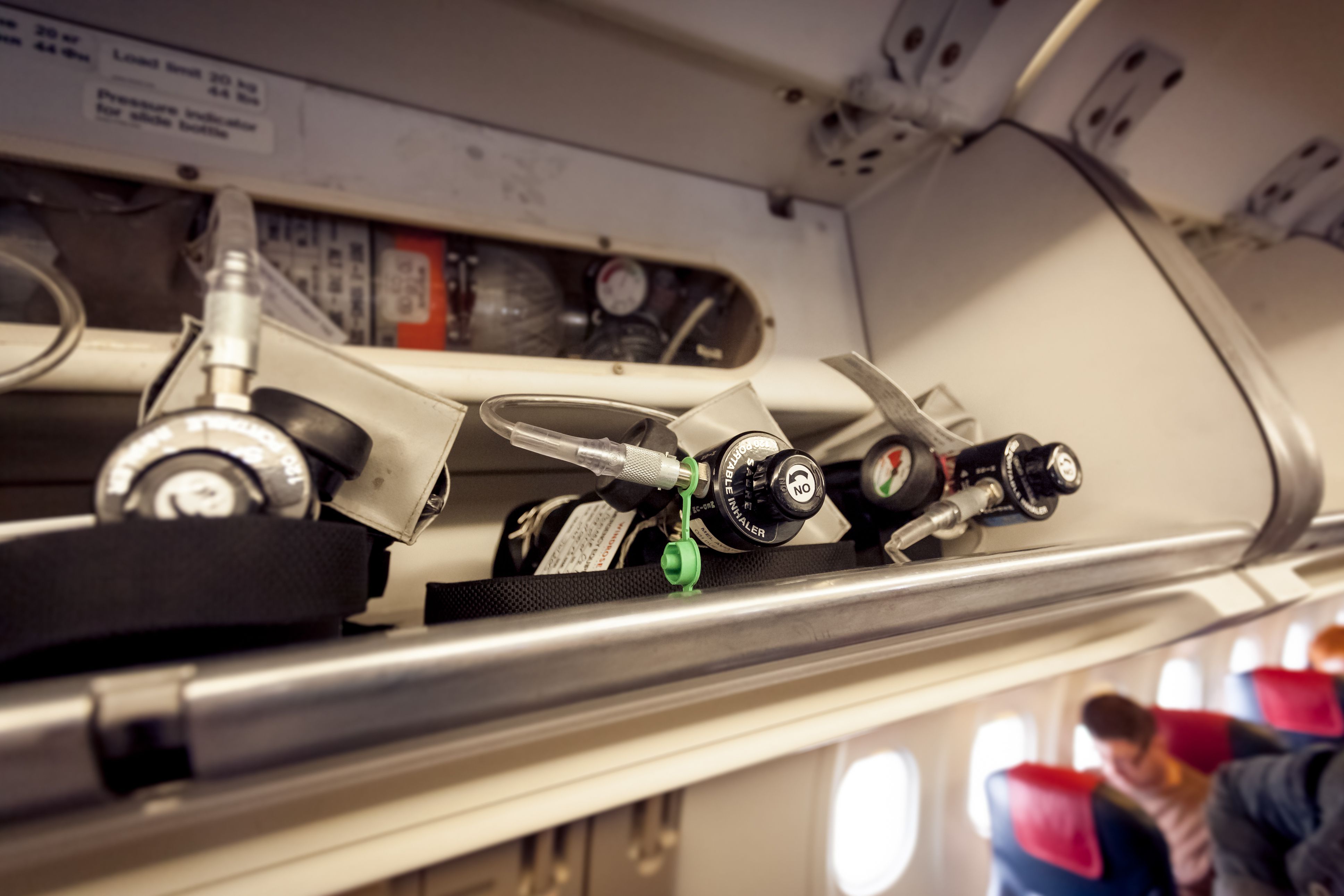 The portable oxygen cylinders in their dedicated overhead storage unit.