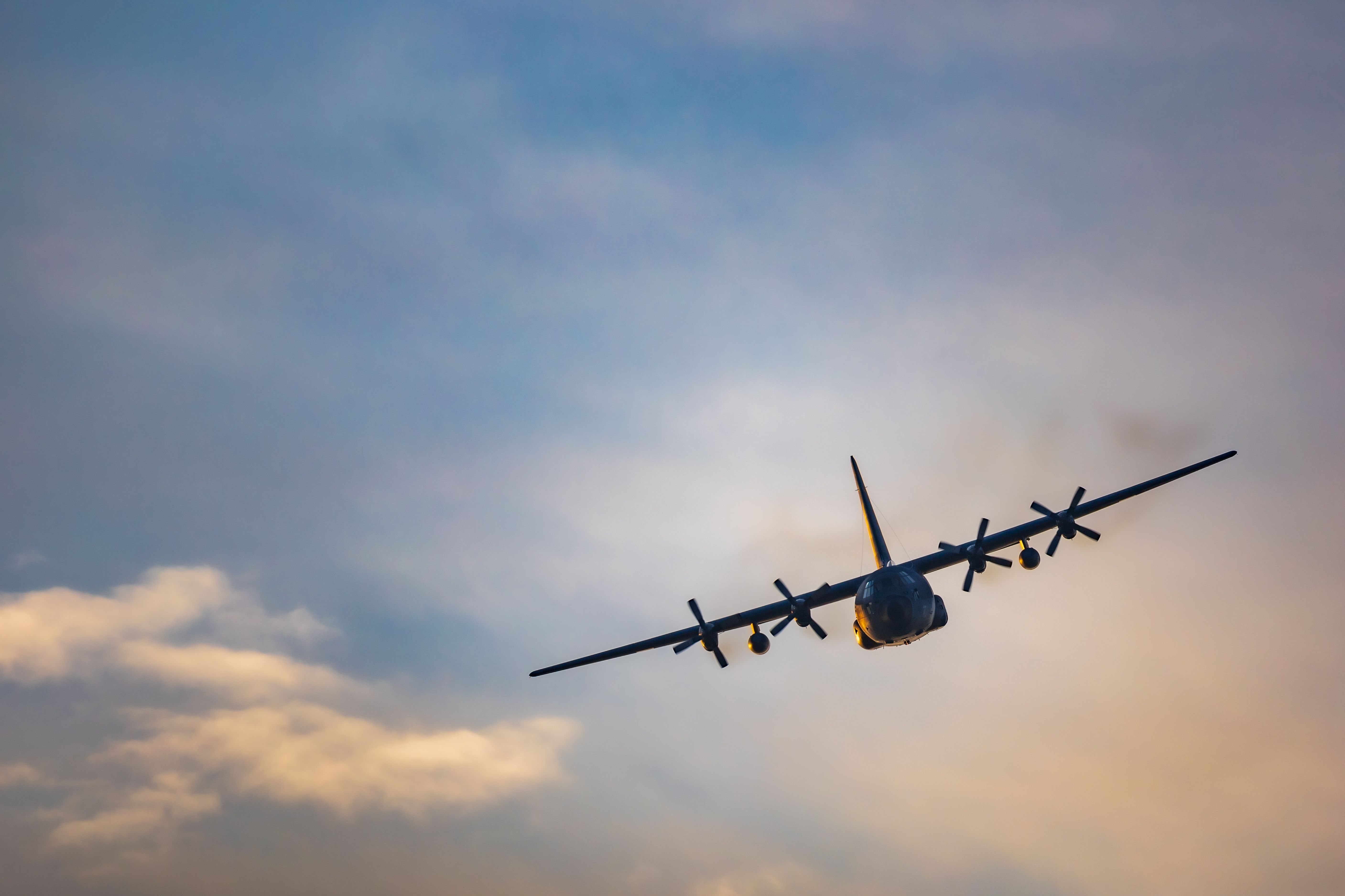 A C-130 Hercules flying in the sky.