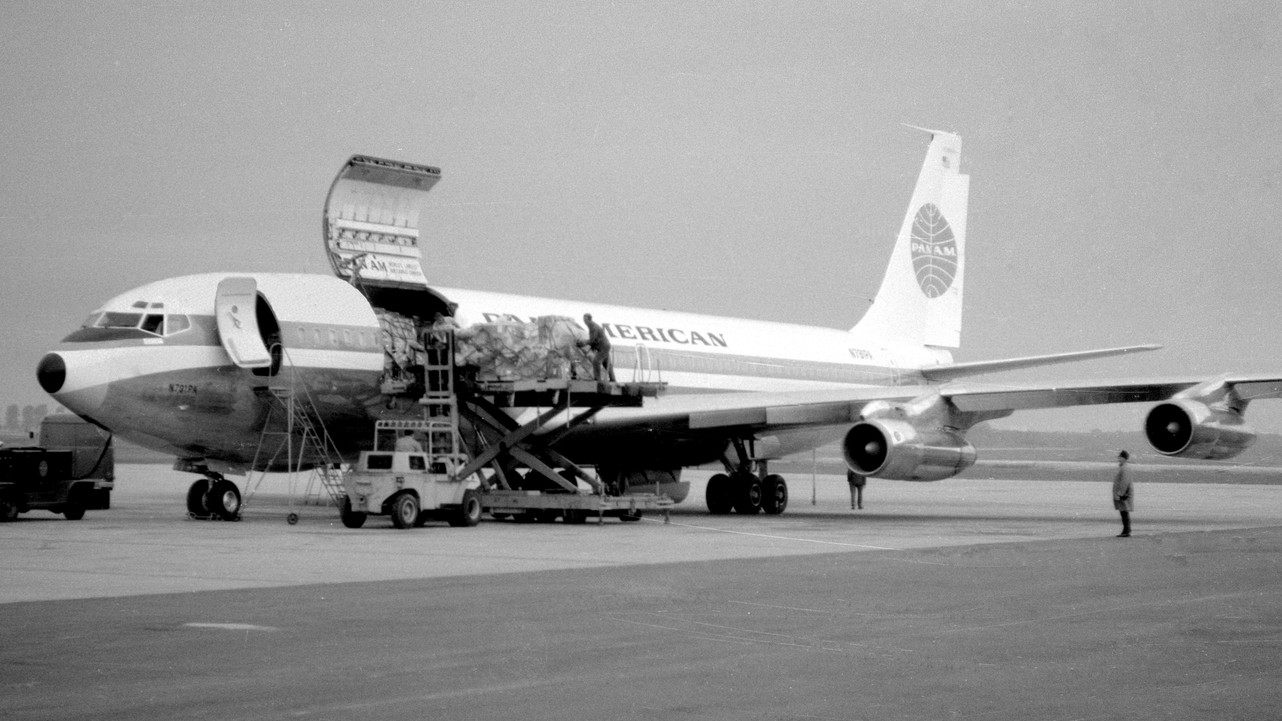A Pan American Boeing 707 being loaded on an airport apron.