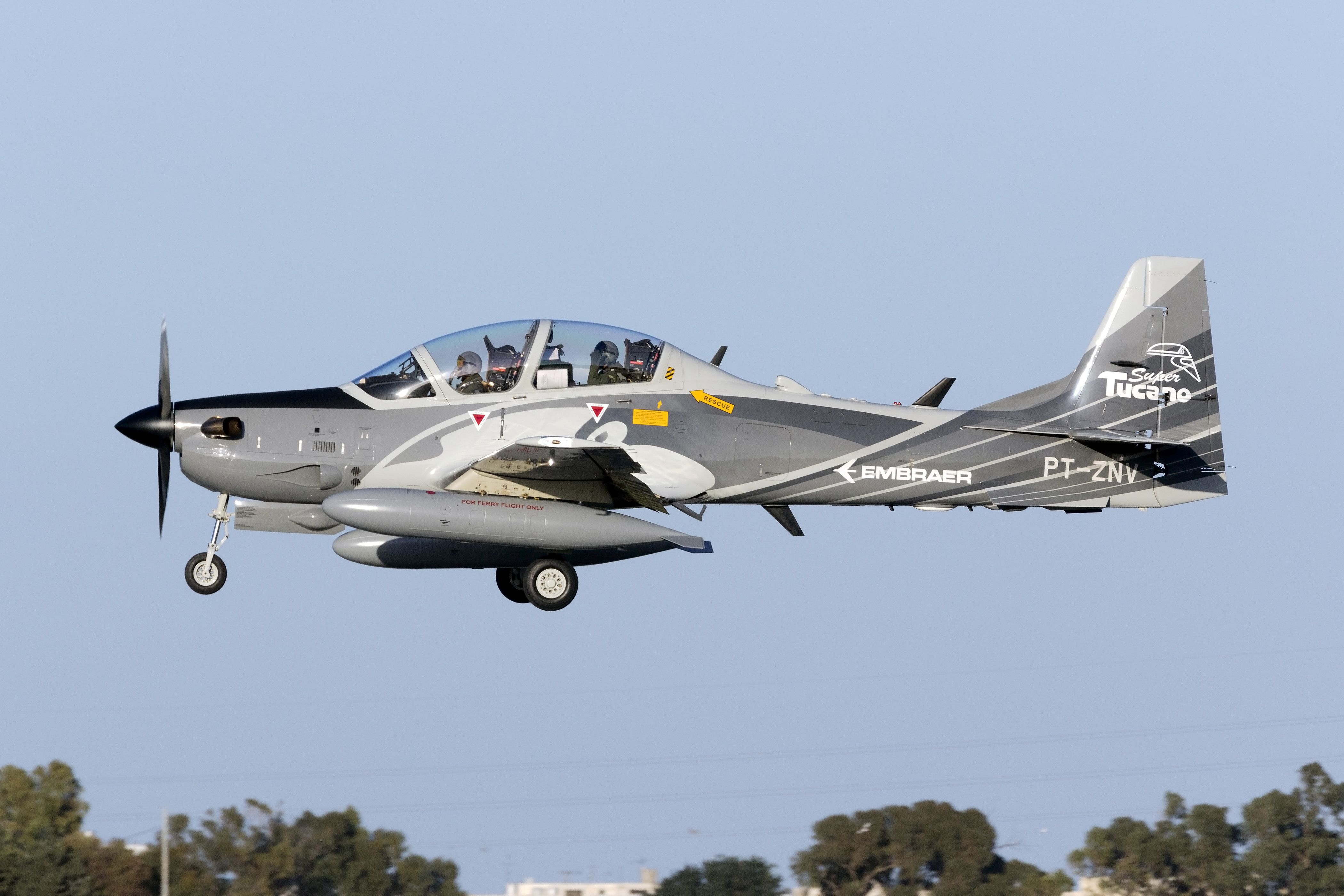 An Embraer A-29 Super Tucano flying in the sky.