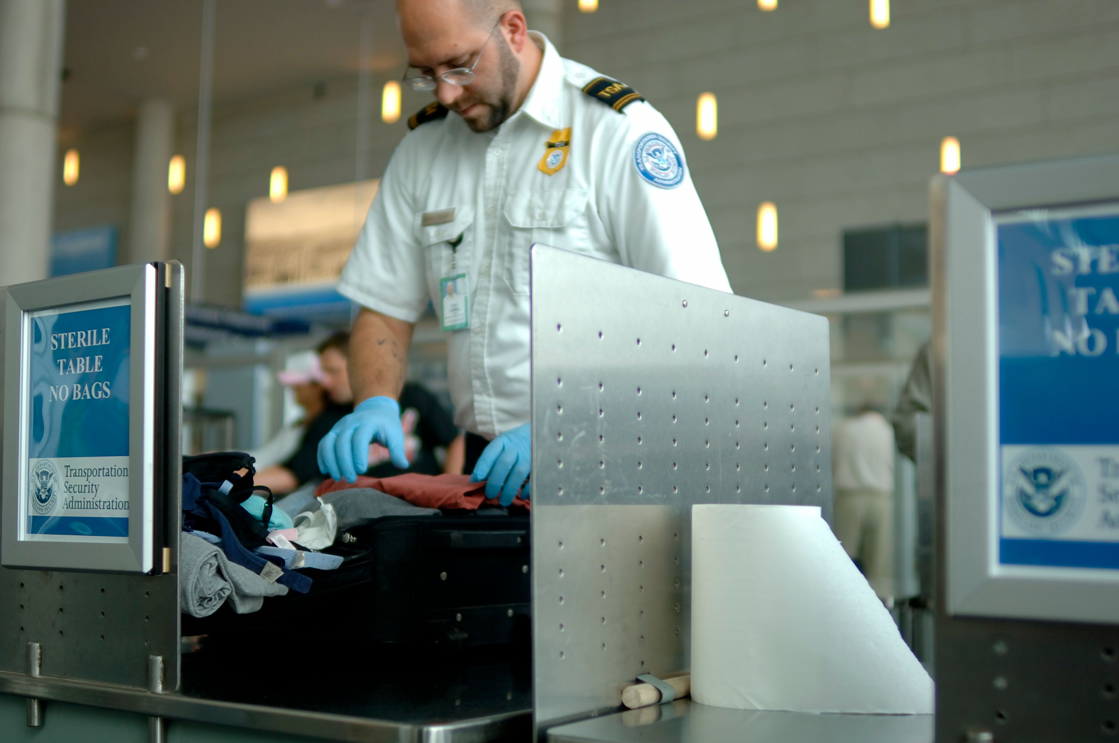 TSA agent searching through bags