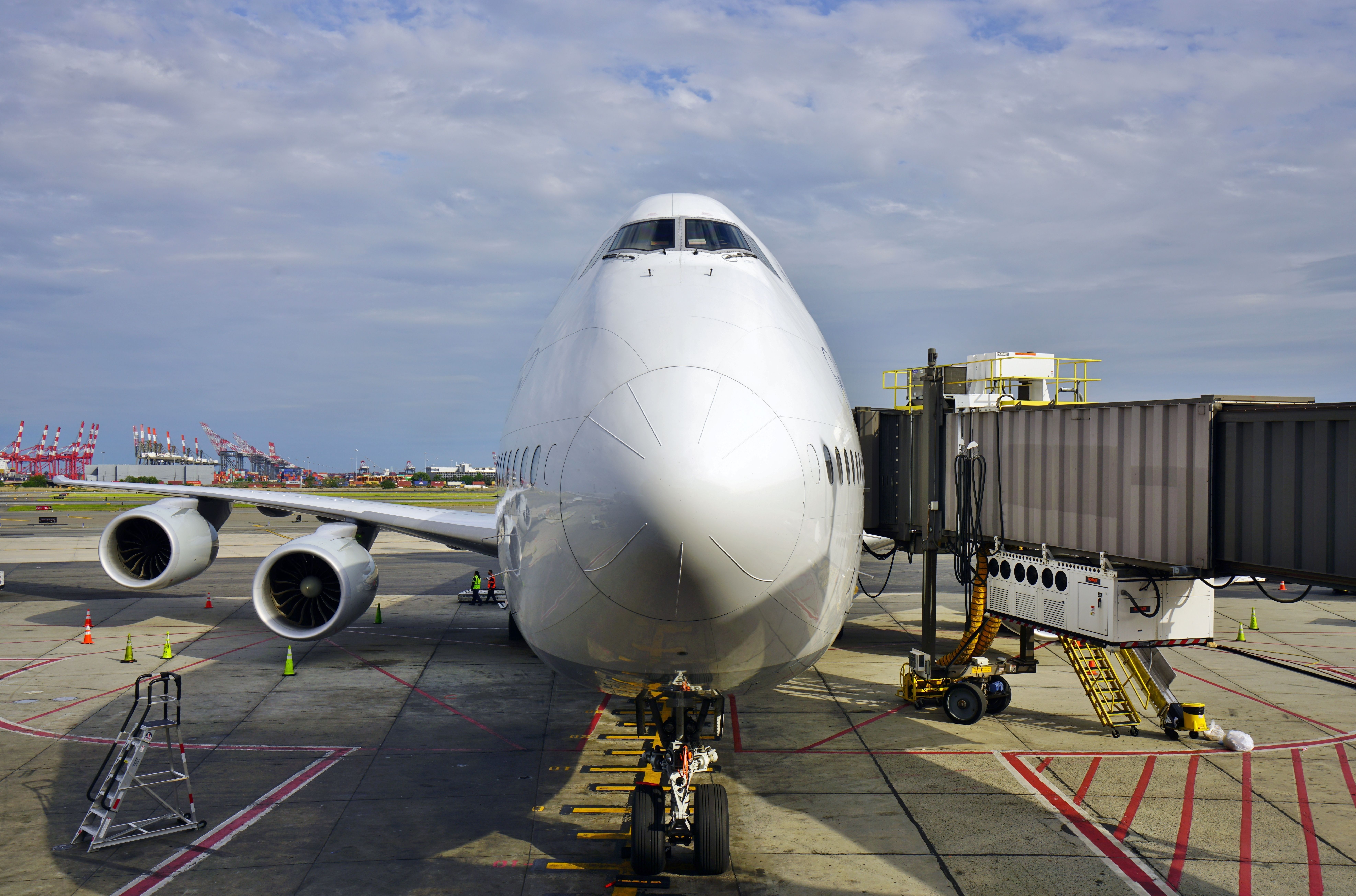 A head-on view of a Lufthansa Boeing 747-8 parked at an airport gate.