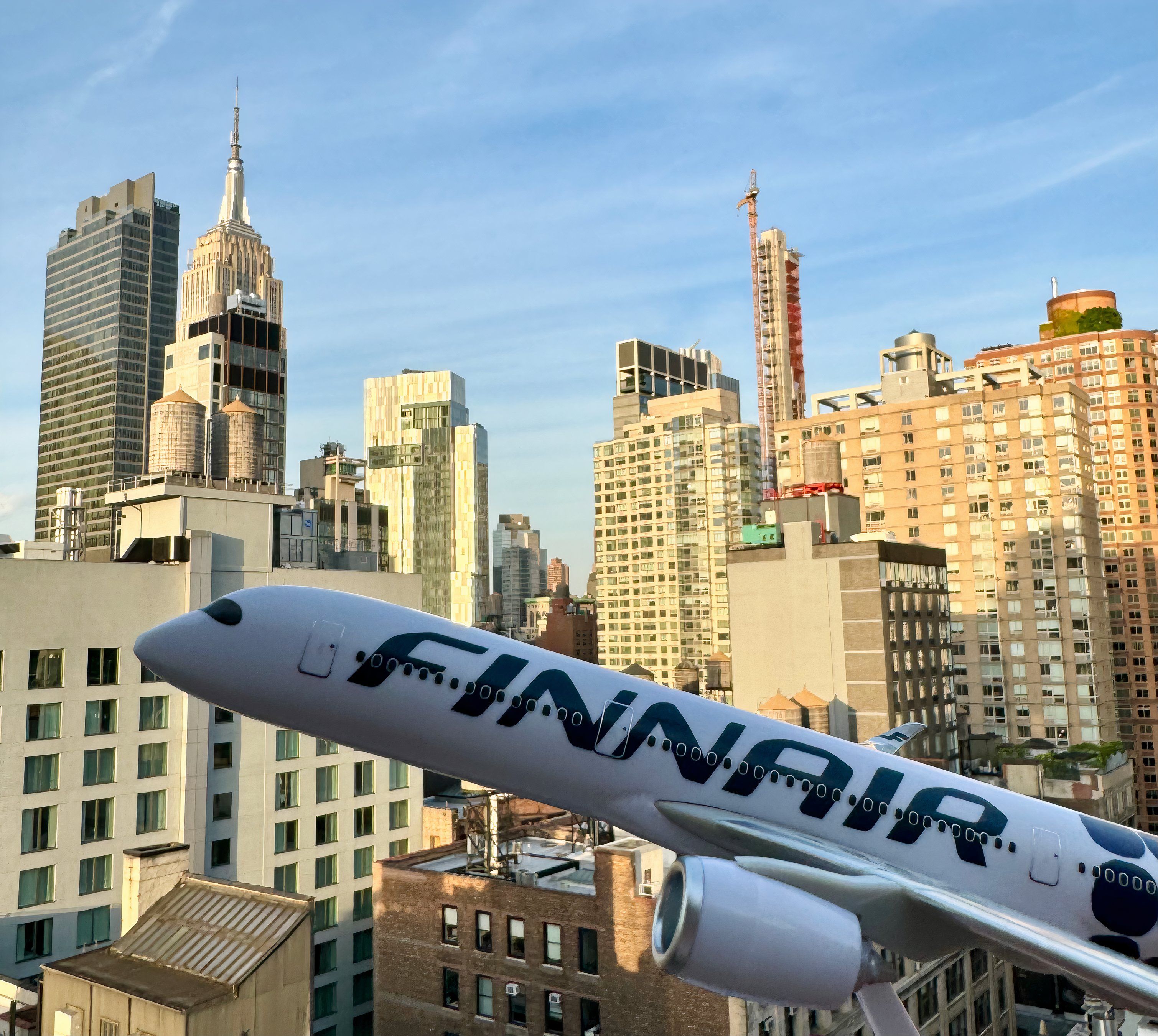 A Finnair plane model in front of the New York City Skyline