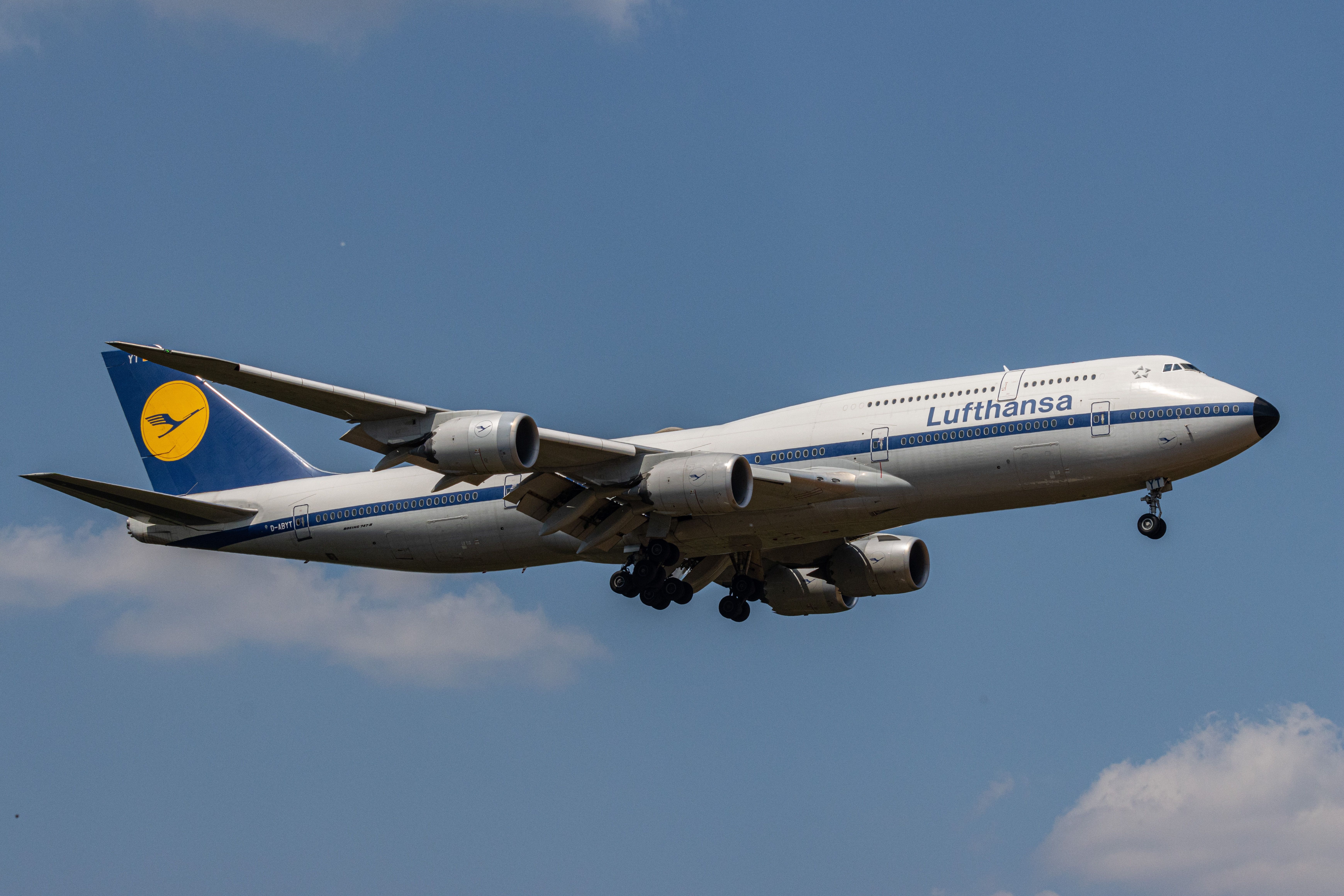 Frankfurt, Germany - June 11 2023: Lufthansa Boeing 747-8i landing at Frankfurt airport (FRA). The plane has a retro livery from the 1970s and is framed against light blue sky with white clouds.