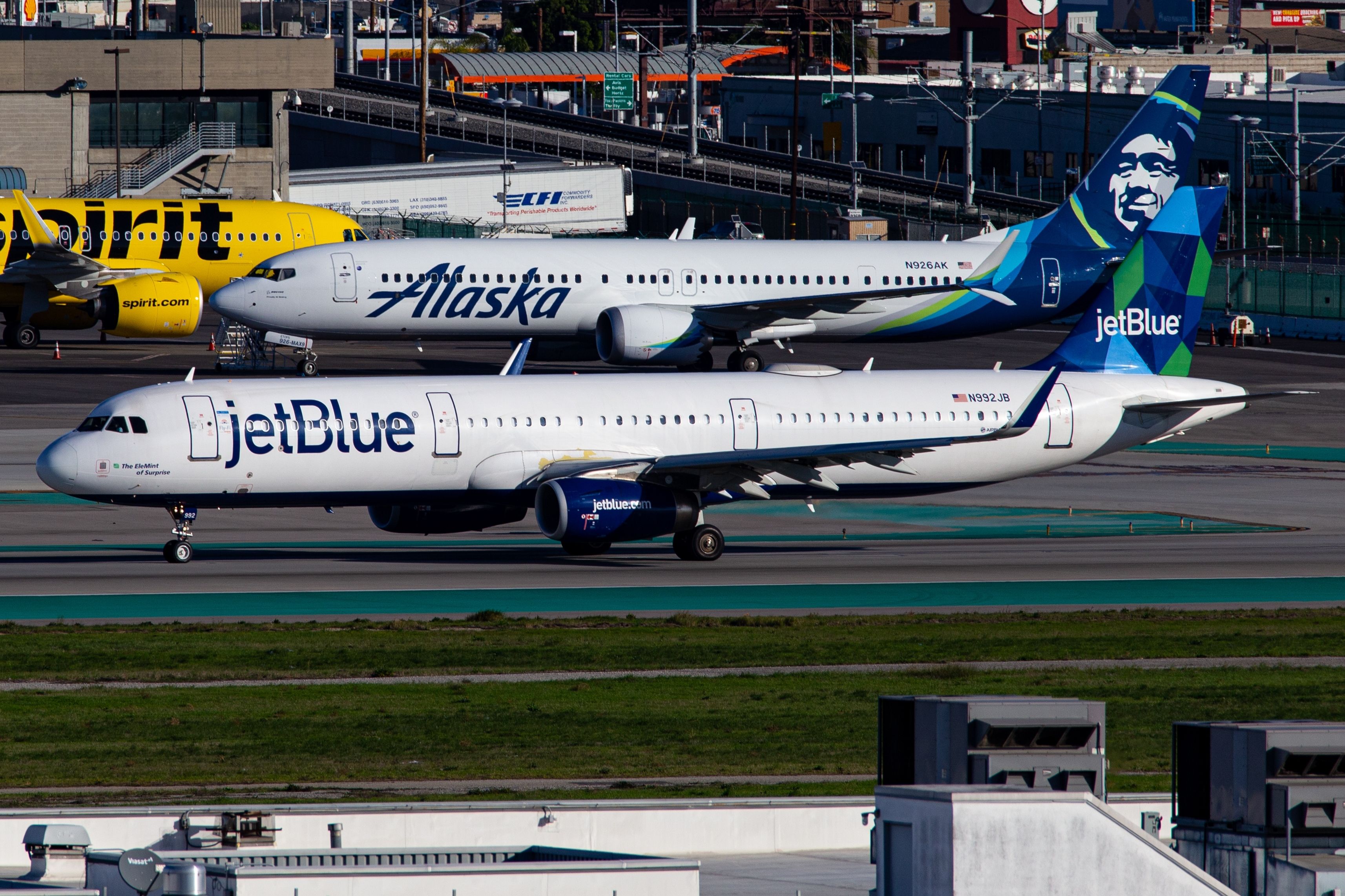 JetBlue Airways Airbus A321-231 at Los Angeles International Airport with Alaska Airlines Boeing 737 MAX 9 and Spirit Airlines Airbus A320N-271 in the background.