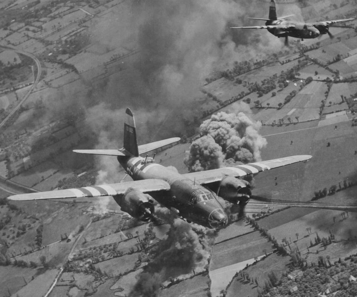 B-26 Marauders with D-Day invasion stripes strike a road and rail junction behind the front lines to slow down enemy reinforcements