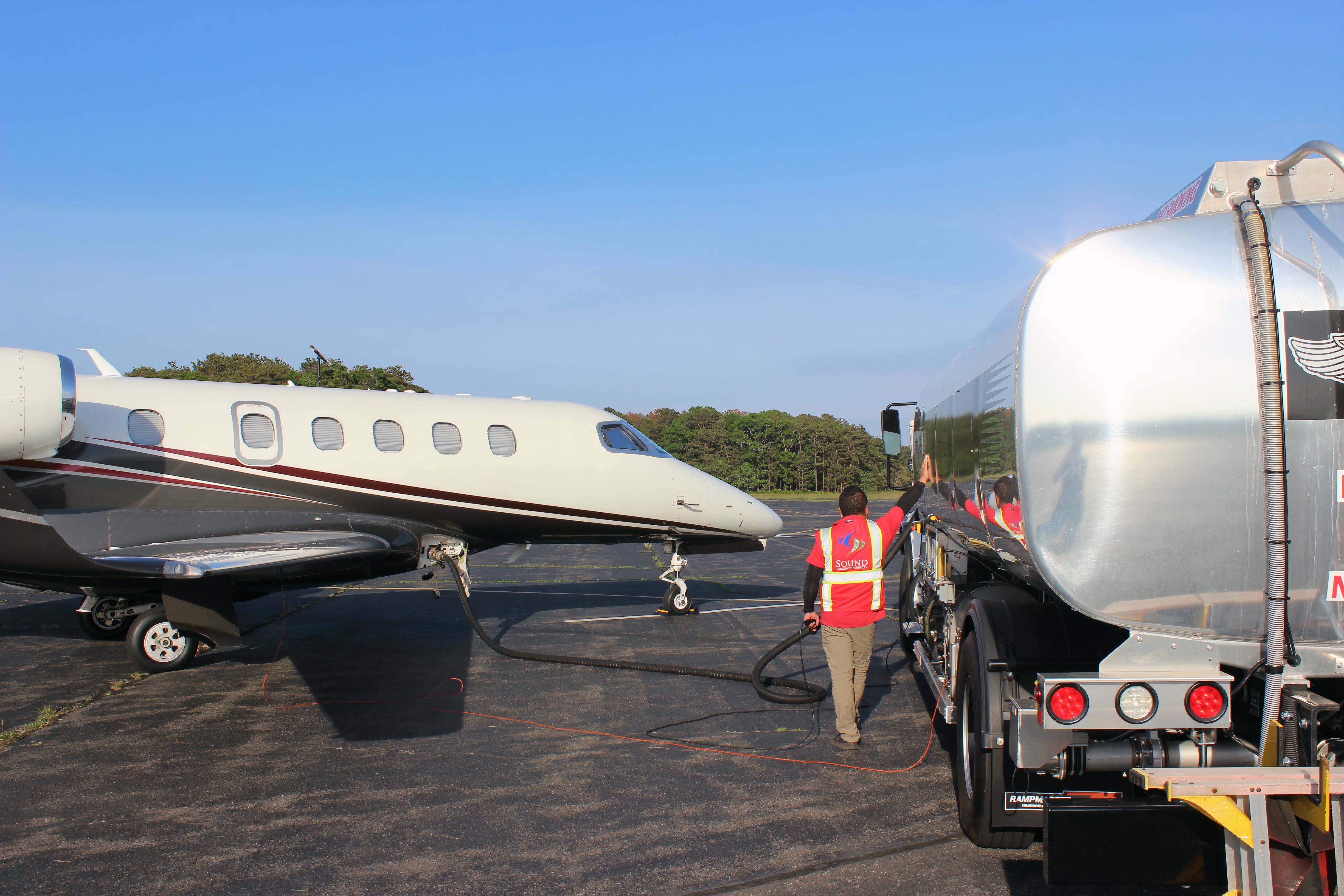 A line service technician fueling an airplane at JPX.