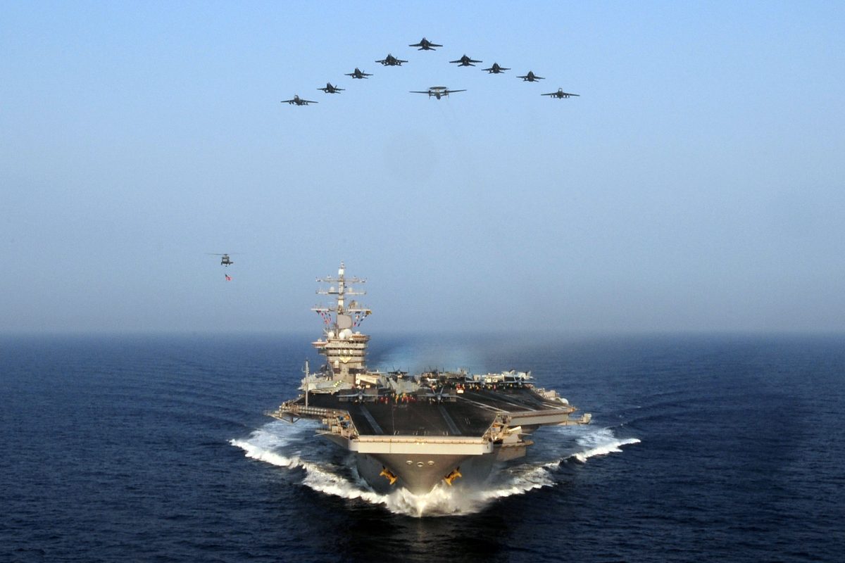 USS Dwight D. Eisenhower with aircraft flying overhead