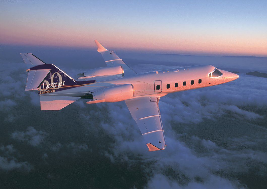 A Learjet 60 in flight above clouds