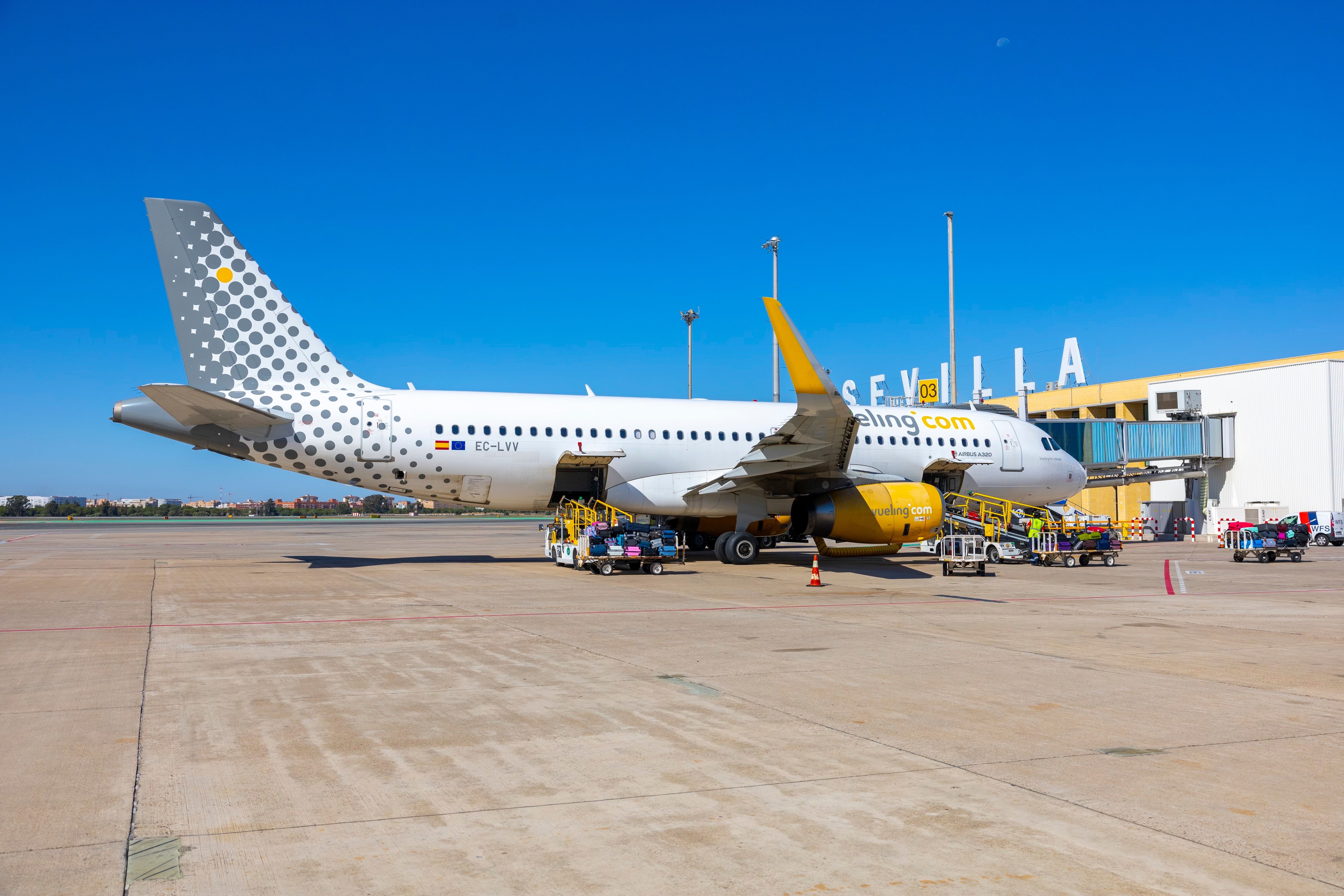 A Vueling Airbus A320 parked at a gate area