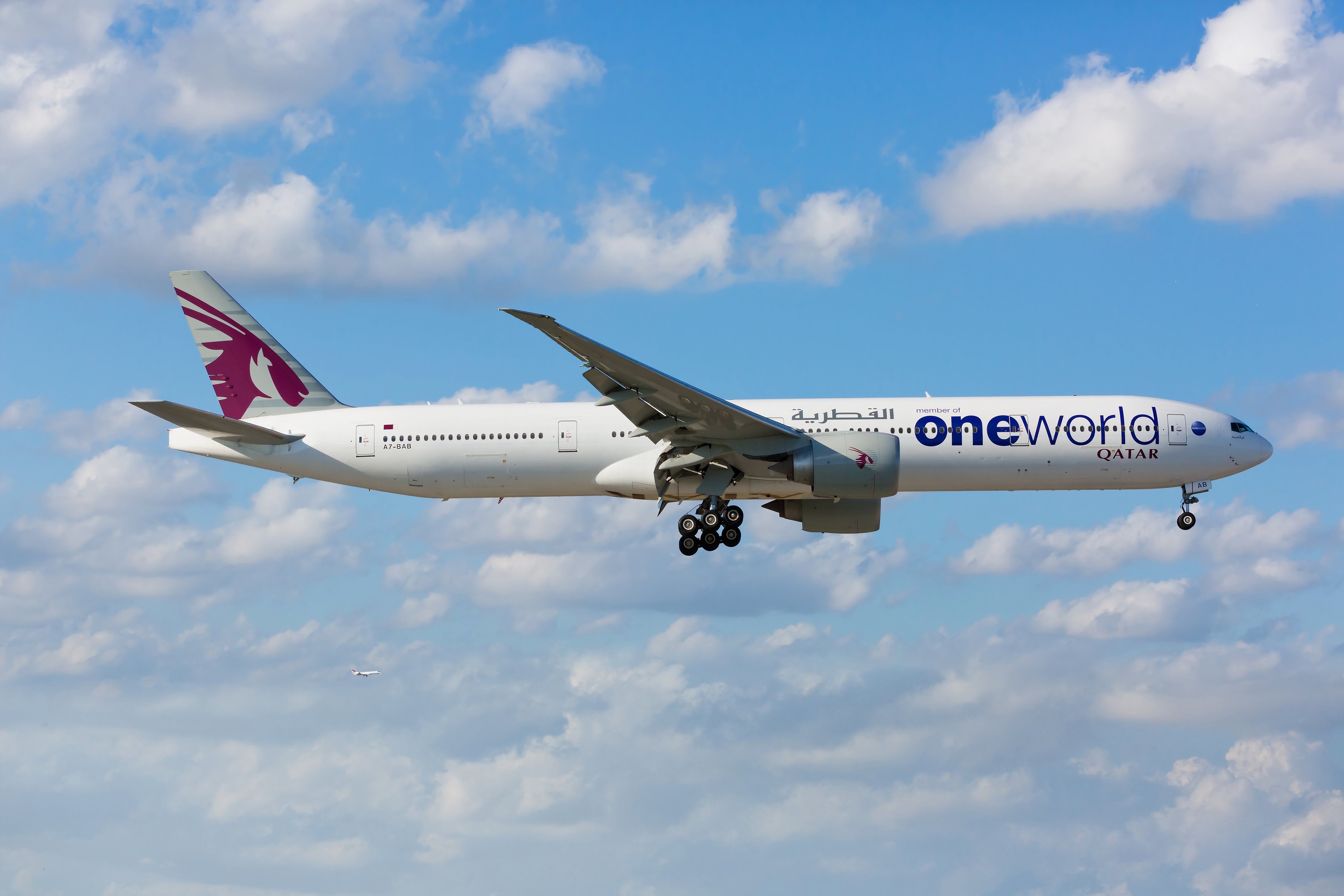 A Boeing 777-300ER aircraft of Qatar Airways displaying the One World livery landing at the Miami International Airport.