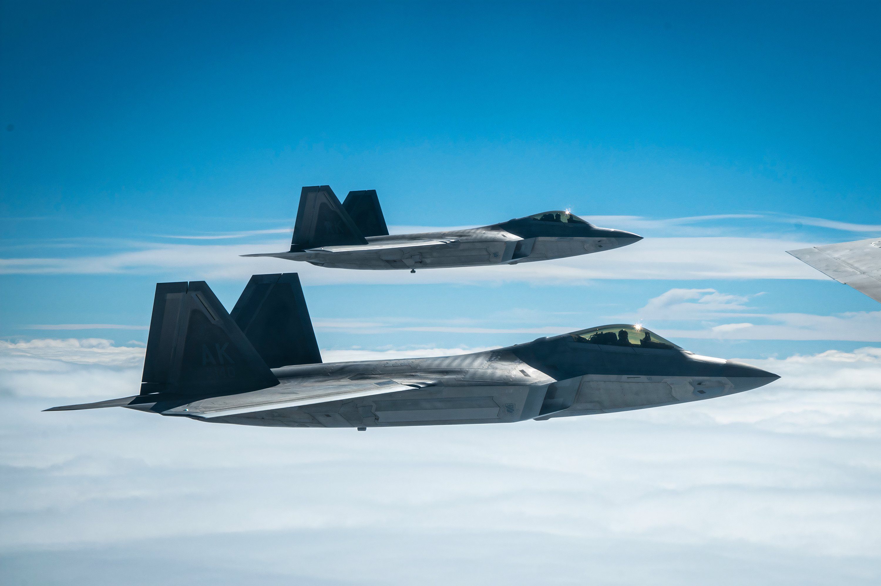 Two F-22 Raptors fly in formation with a KC-135 Stratotanker during exercise Royal Flush over Alaska