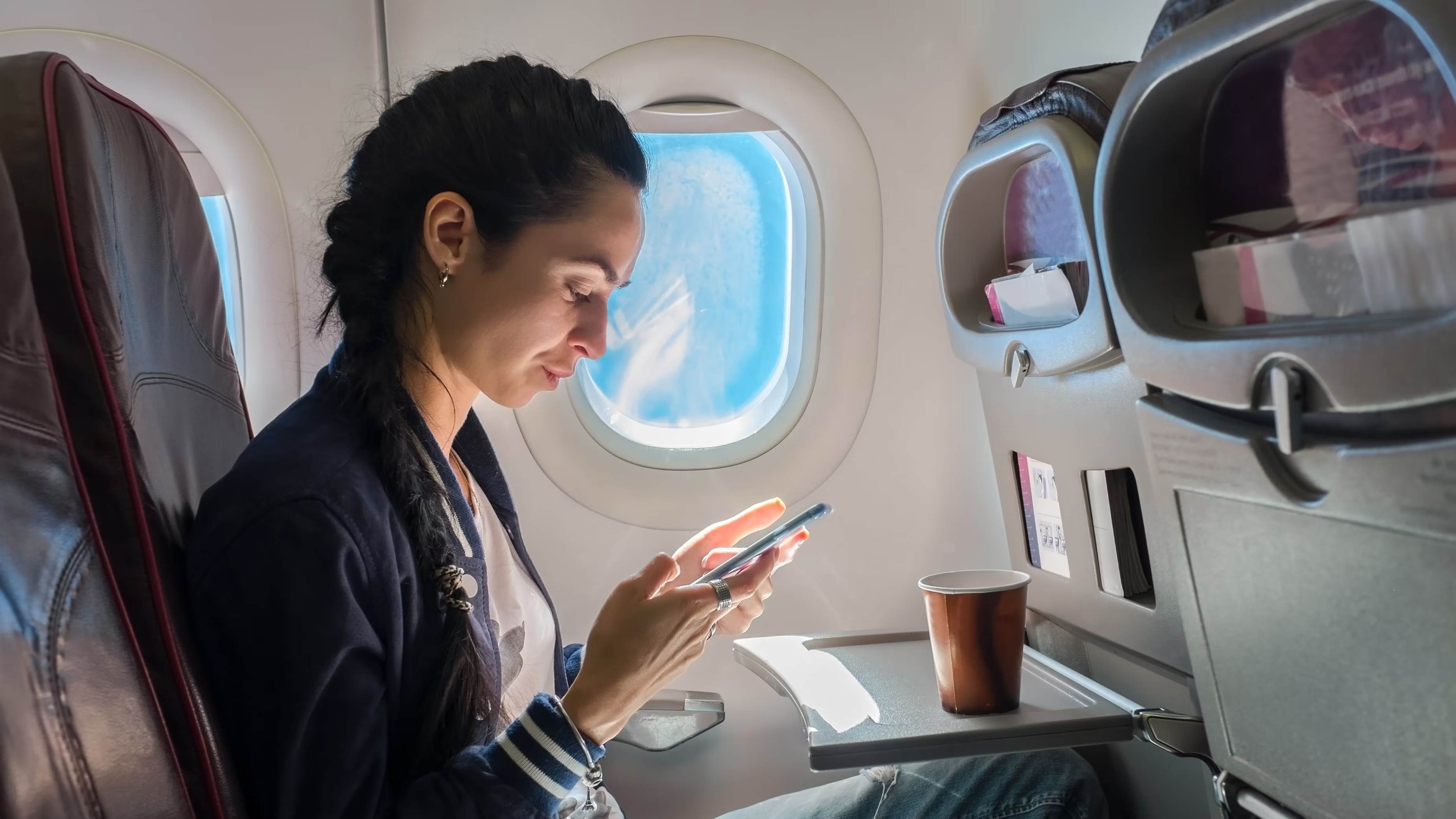 A passenger using a phone on a plane.