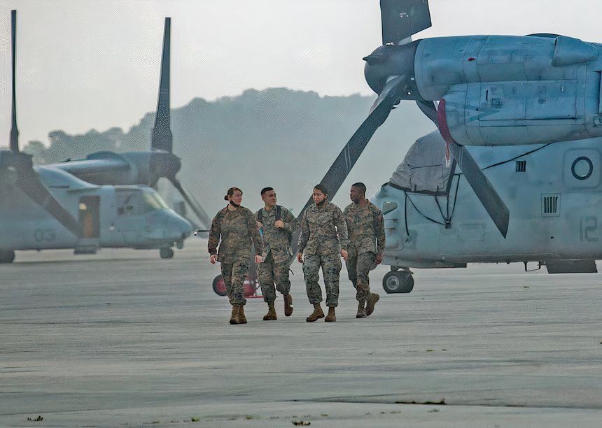 Photo of U.S. Marines preparing to board MV-22 Ospreys during a humanitarian aid mission in Haiti