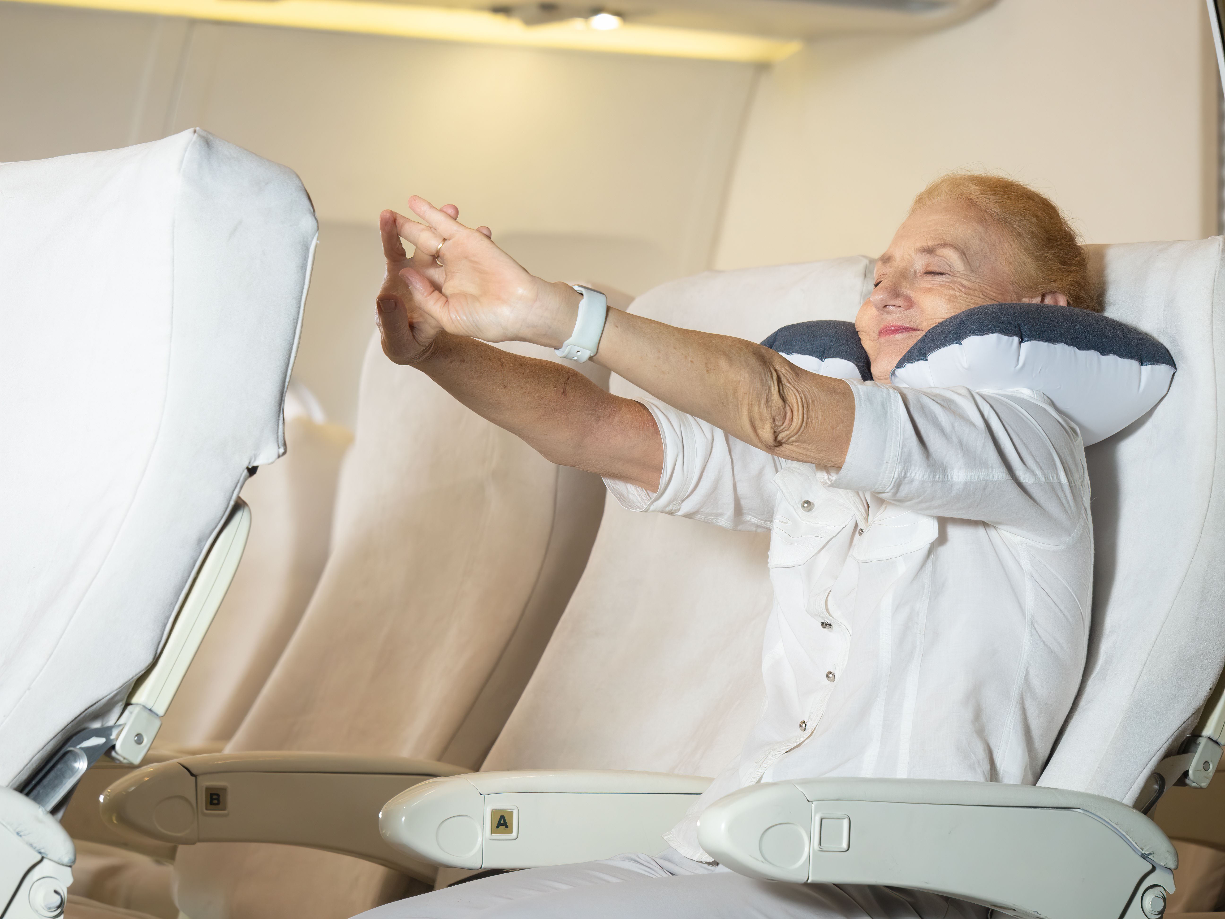 Older lady stretching on an airplane