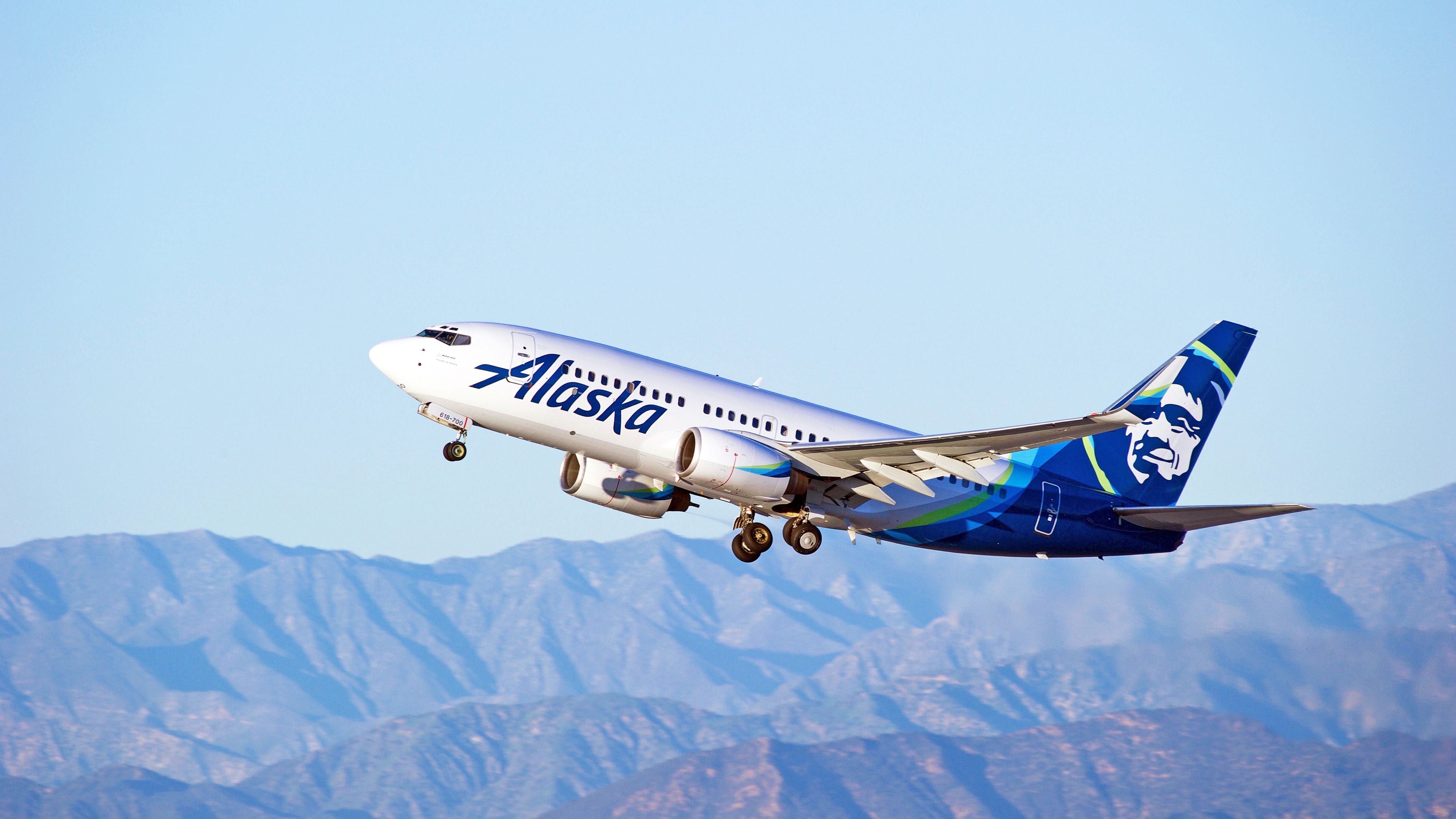 An Alaska Airlines plane in front of Mountains