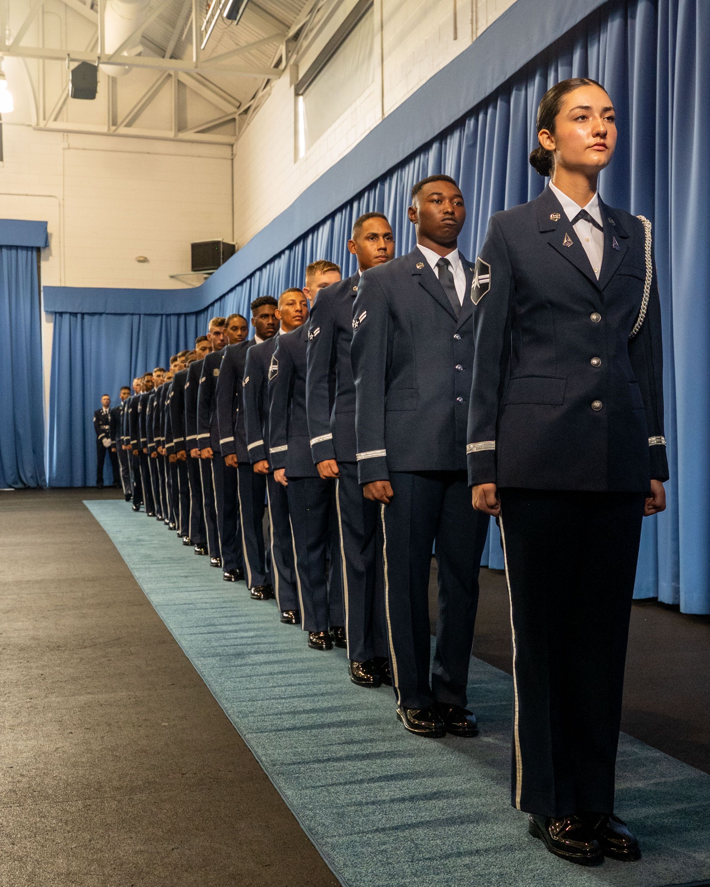 Six U.S. Space Force Guardians and 12 U.S. Air Force Airmen stand in a single file