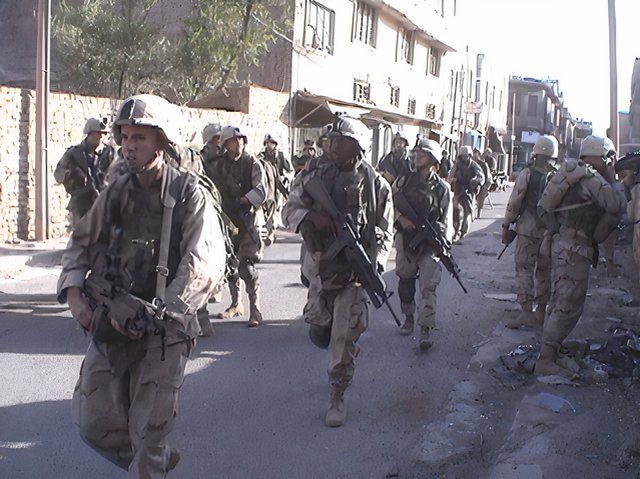 A company sized unit patrols the streets of Iraq.