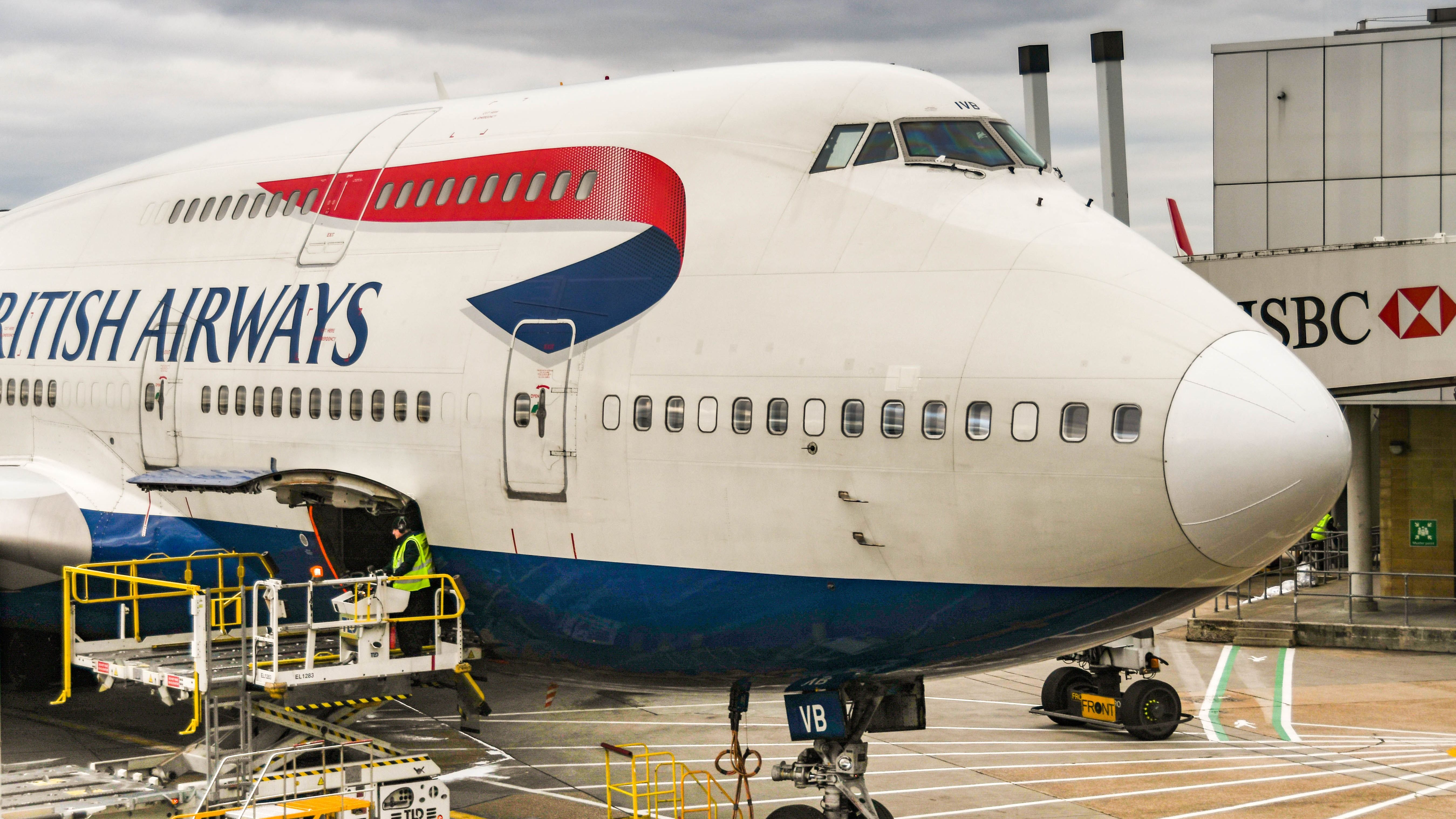 LONDON, ENGLAND - FEBRUARY 2019: Gate pallet loader and open cargo door ready to load air cargo onto a British Airways Boeing 747 jet at London Heathrow Airport,