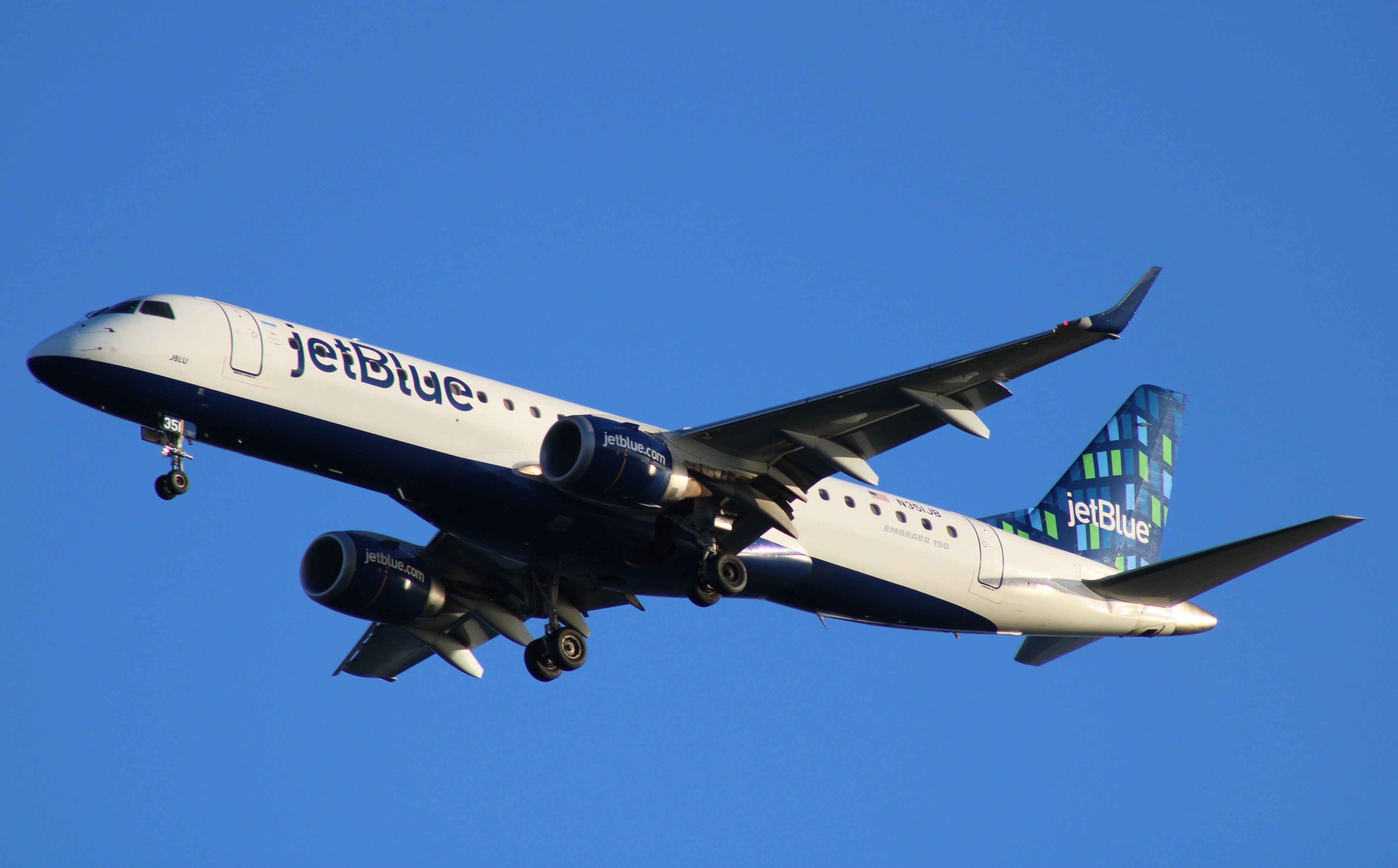 A JetBlue Airbus A220 flies in the sky