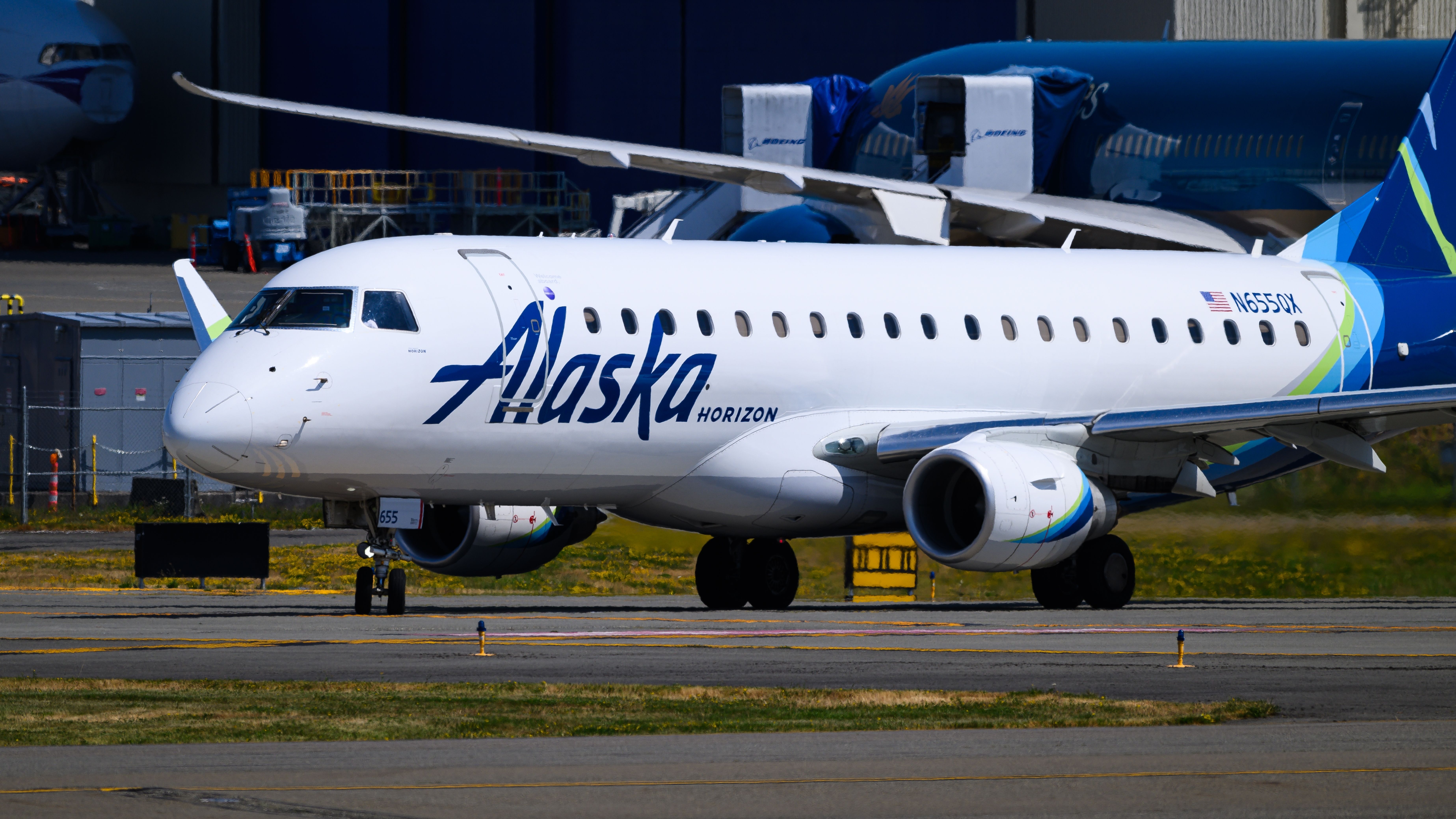 Alaska Airlies Horizon Embraer 175 taxiing on a hot summer day with name and logo on the tail N655QX