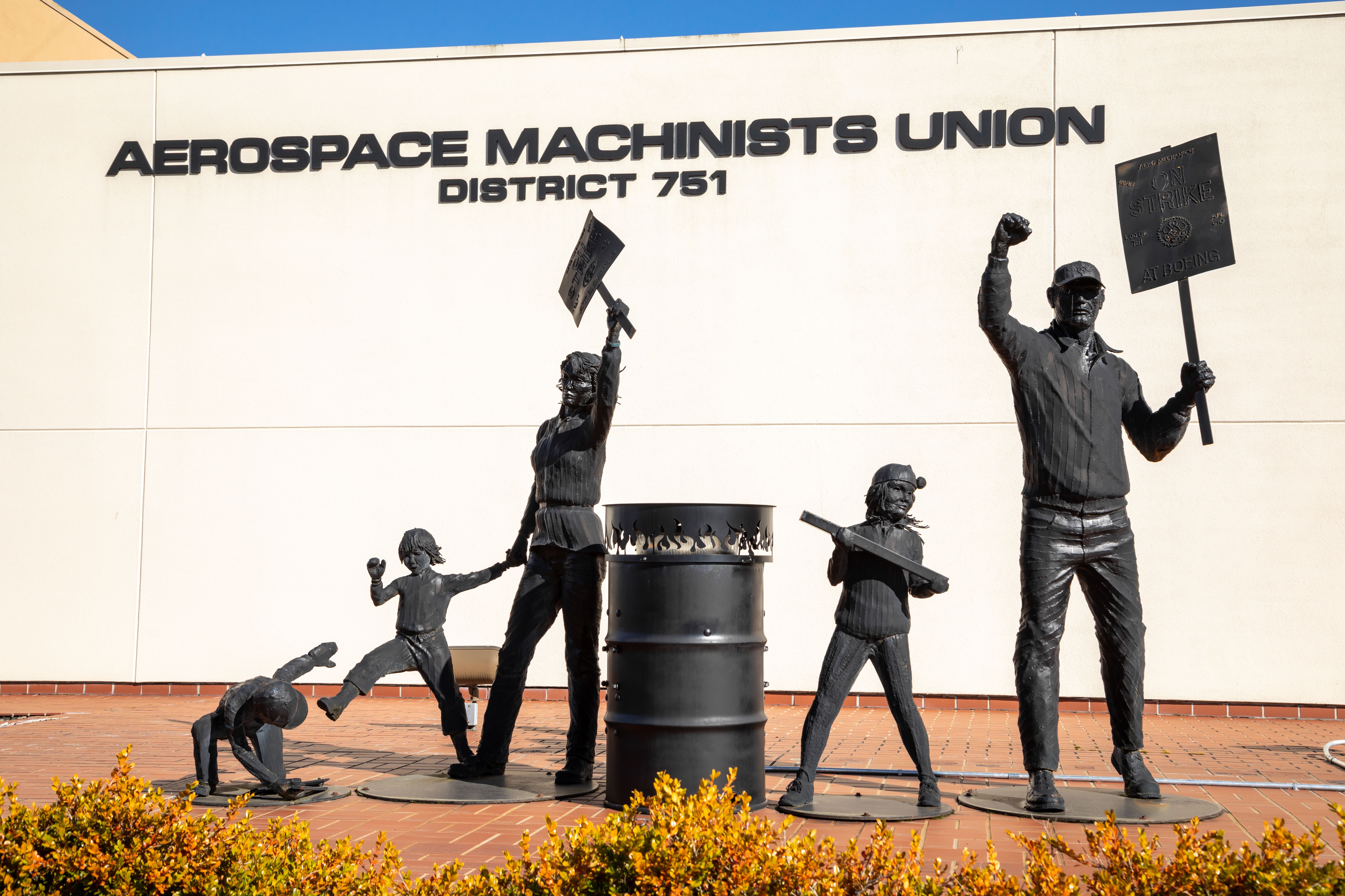 Statues of picketing IAM District 751 employees in front of the union's offices shutterstock_1723191070