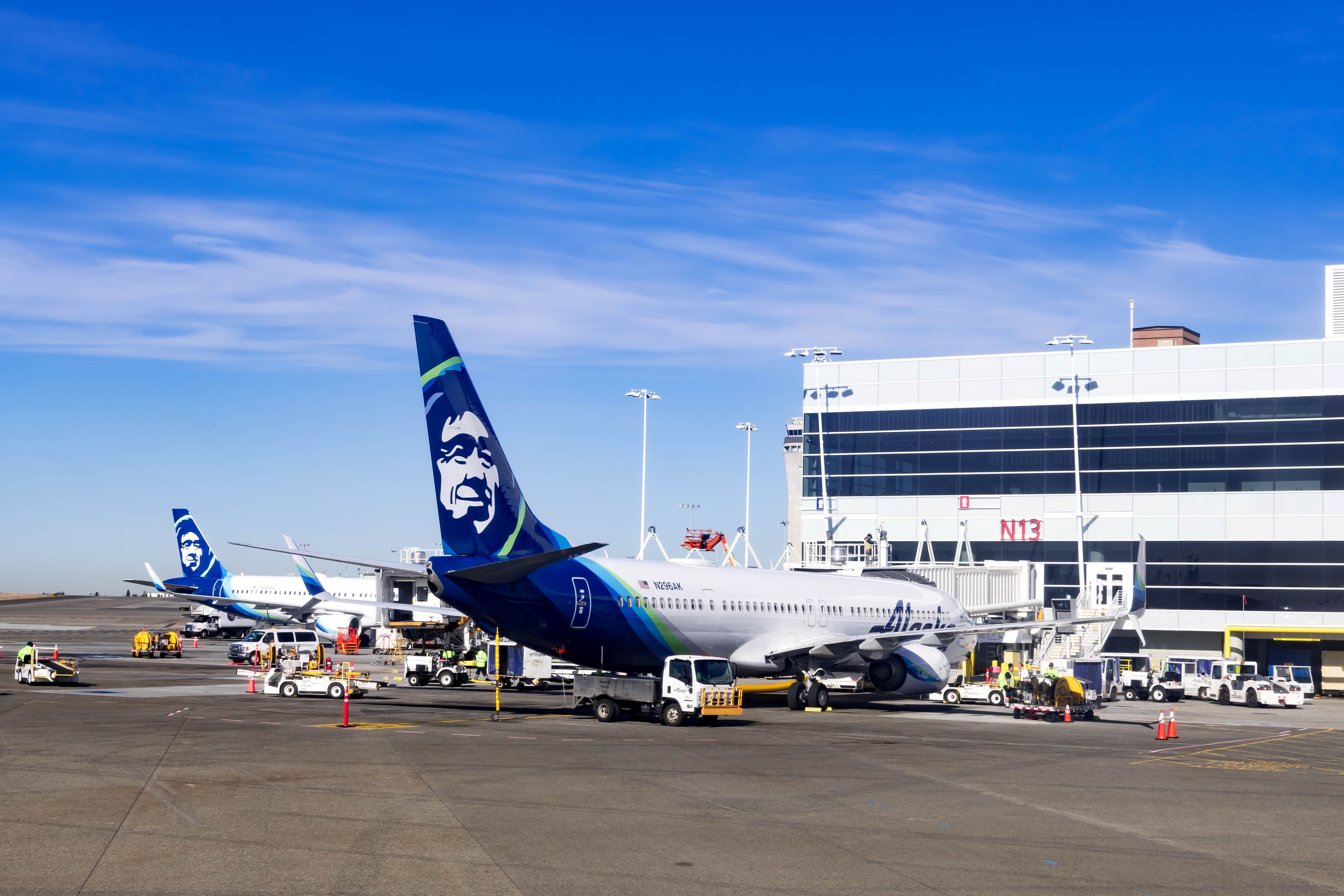 Alaska Airlines planes parked in front of the gates of SEA Shutterstock_1766083010