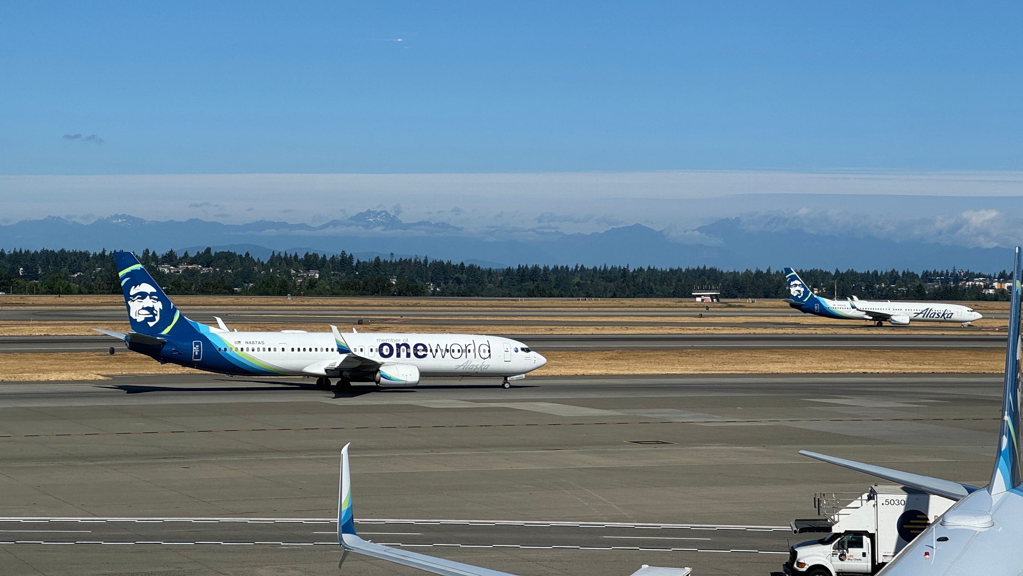 Alaska Airlines planes at SEA, one of which is flying the oneworld livery